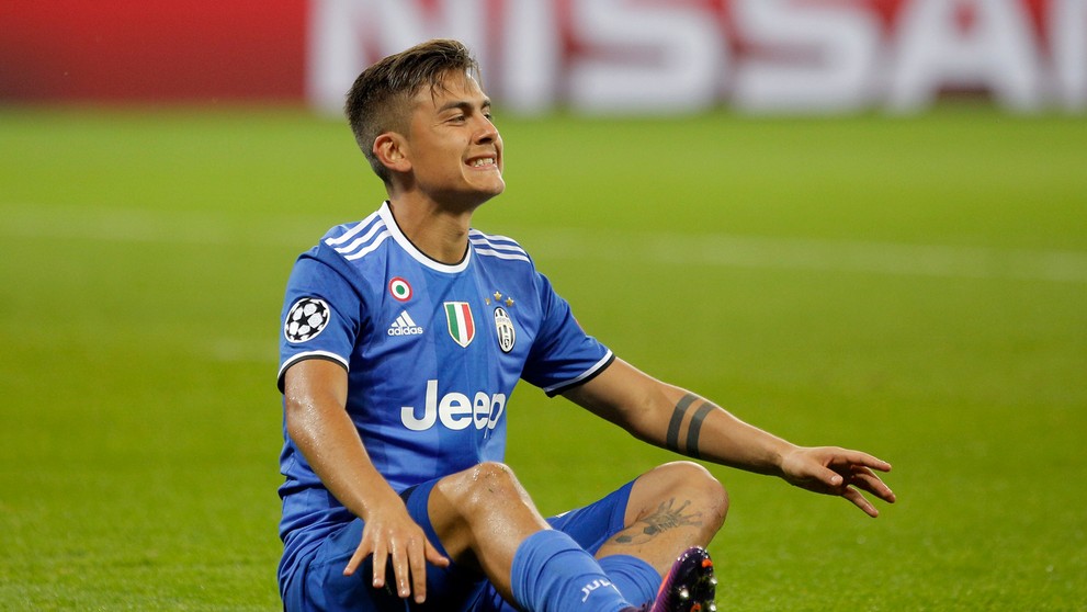 Kanonier Juventusu Psulo Dybala sedí na trávniku v Lyone počas duelu LM.