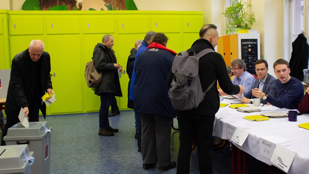 Voliči vo volebnej miestnosti.