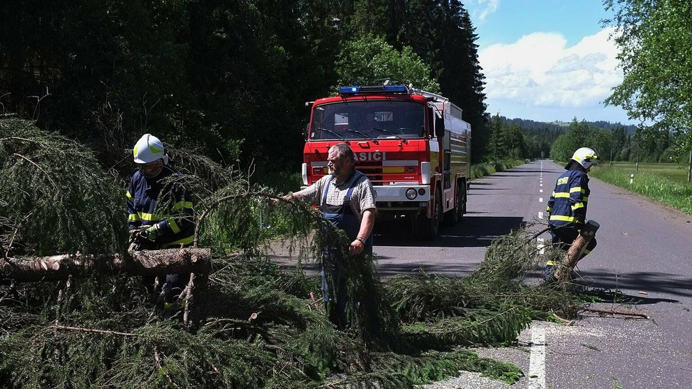 Na snímke hasiči a dobrovoľní hasiči zo Ždiaru odpratávajú popadané stromy z cesty