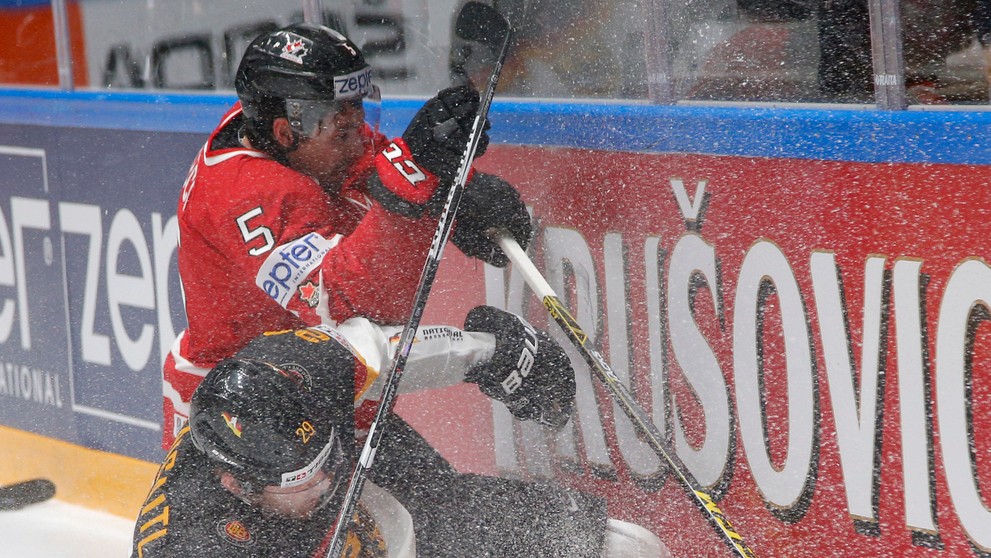 Hráč Kanady Cody Ceci (hore) a hráč Nemecka Leon Draisaitl (dolu) v súboji o puk v zápase B-skupiny MS v Rusku.