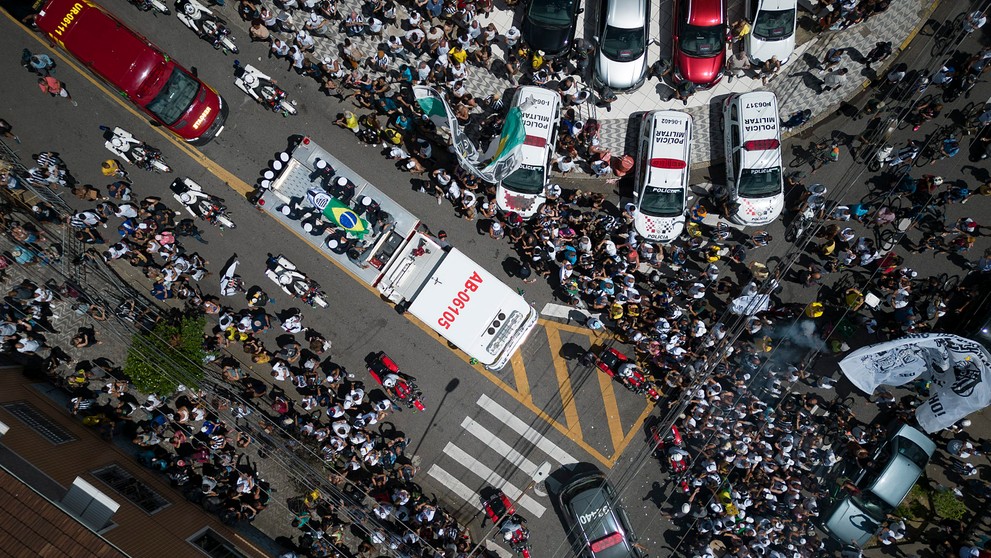 Rakva s pozostkami zosnulého brazílskeho legendárneho futbalistu Pelého je zakrytá brazílskou vlajkou a vlajkou klubu Santos FC počas prevozu zo štadióna Vila Belmiro na cintorín Memorial Necropole Ecumenica.
