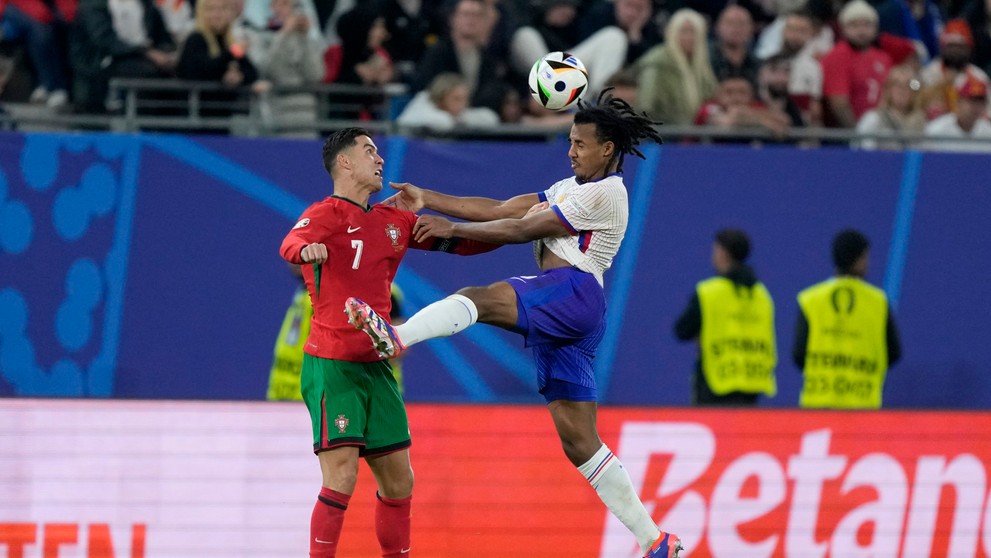 Cristiano Ronaldo a Jules Kounde v súboji.