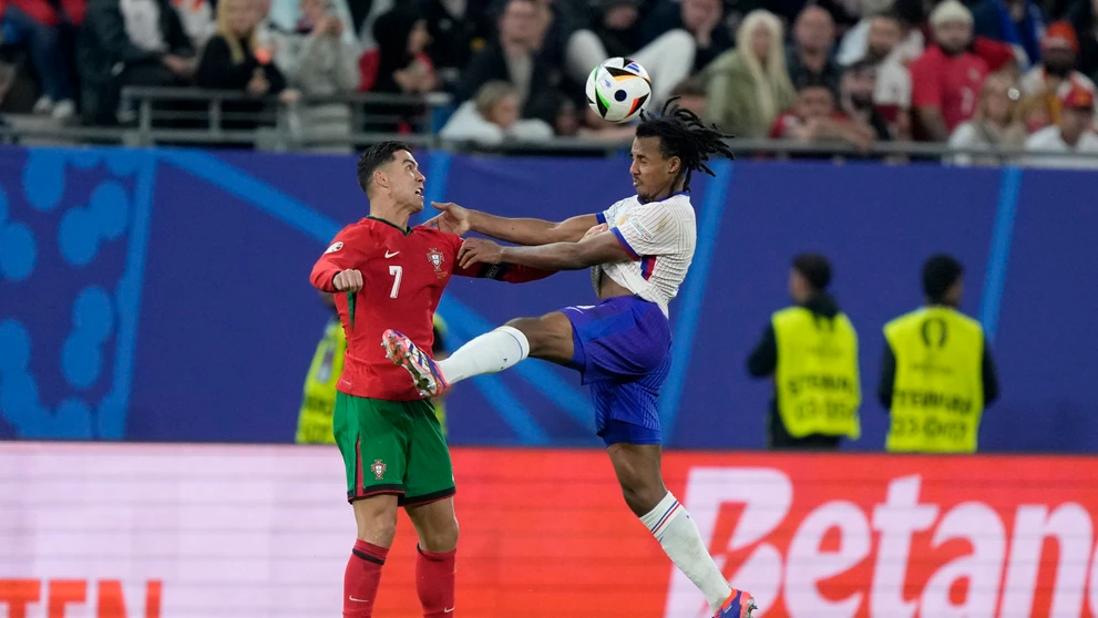 Cristiano Ronaldo a Jules Kounde v súboji.