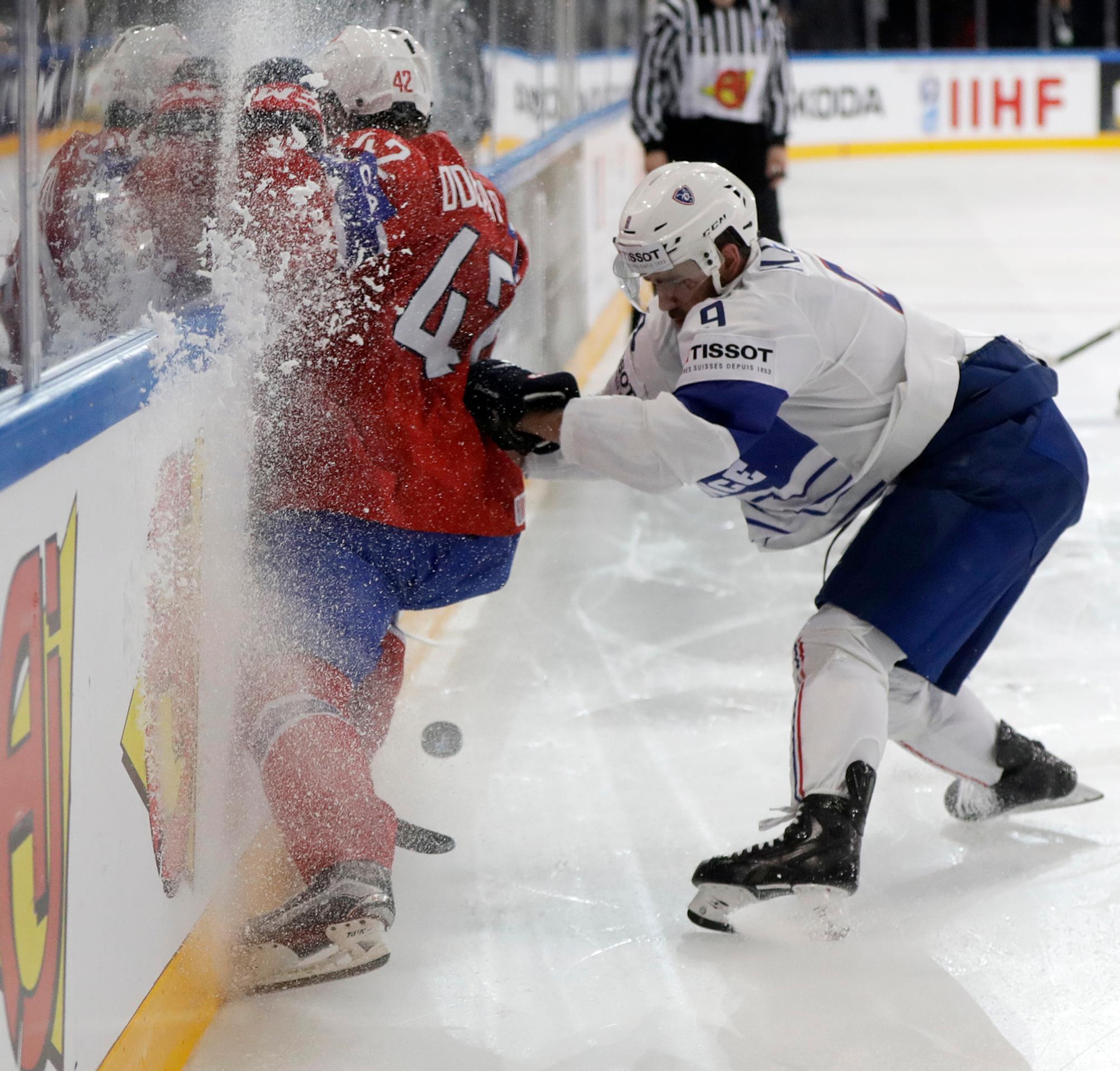 Francúz Damien Fleury odtláča od puku Nóra Henrika Odegaarda.