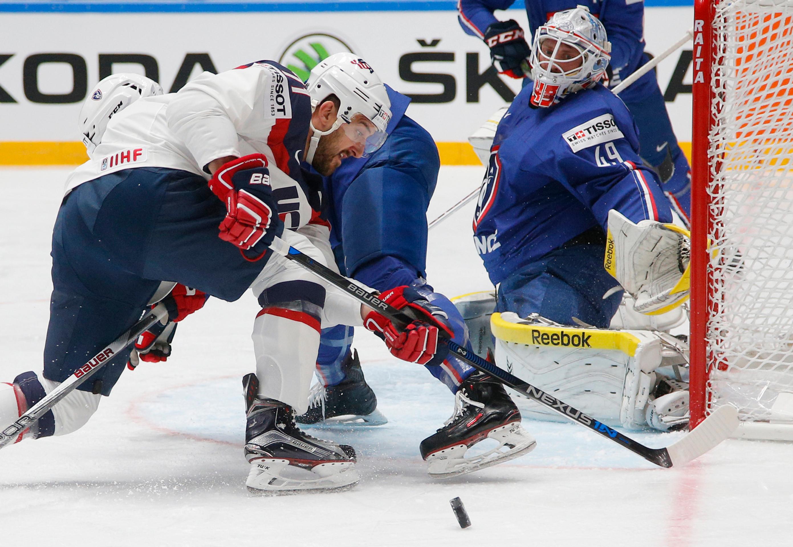 Hráč USA Nick Foligno (vľavo) v súboji o puk pred brankárom Francúzska Florianom Hardym.