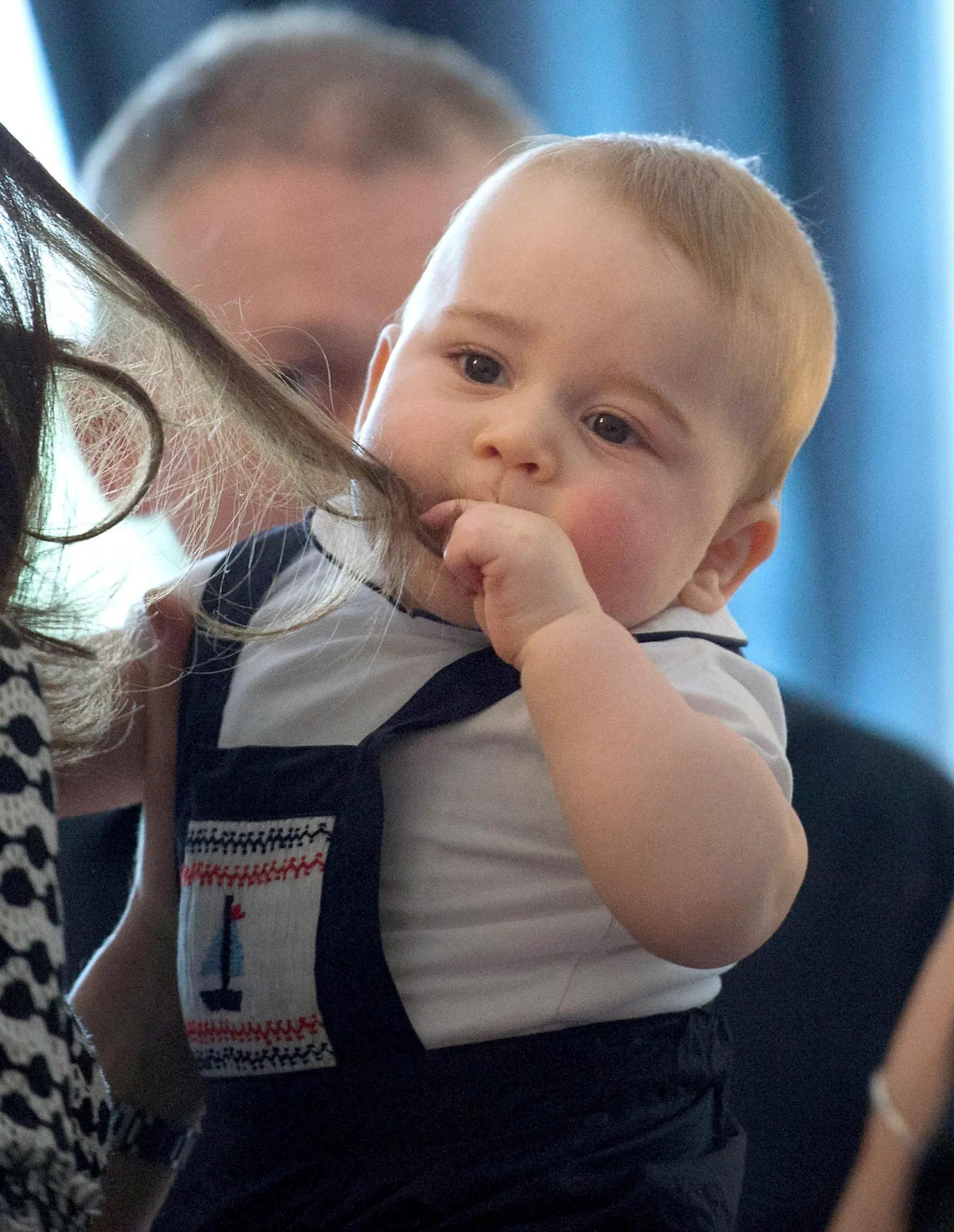 Britský princ George sa hrá s vlasmi Kate 9. apríla 2014.
