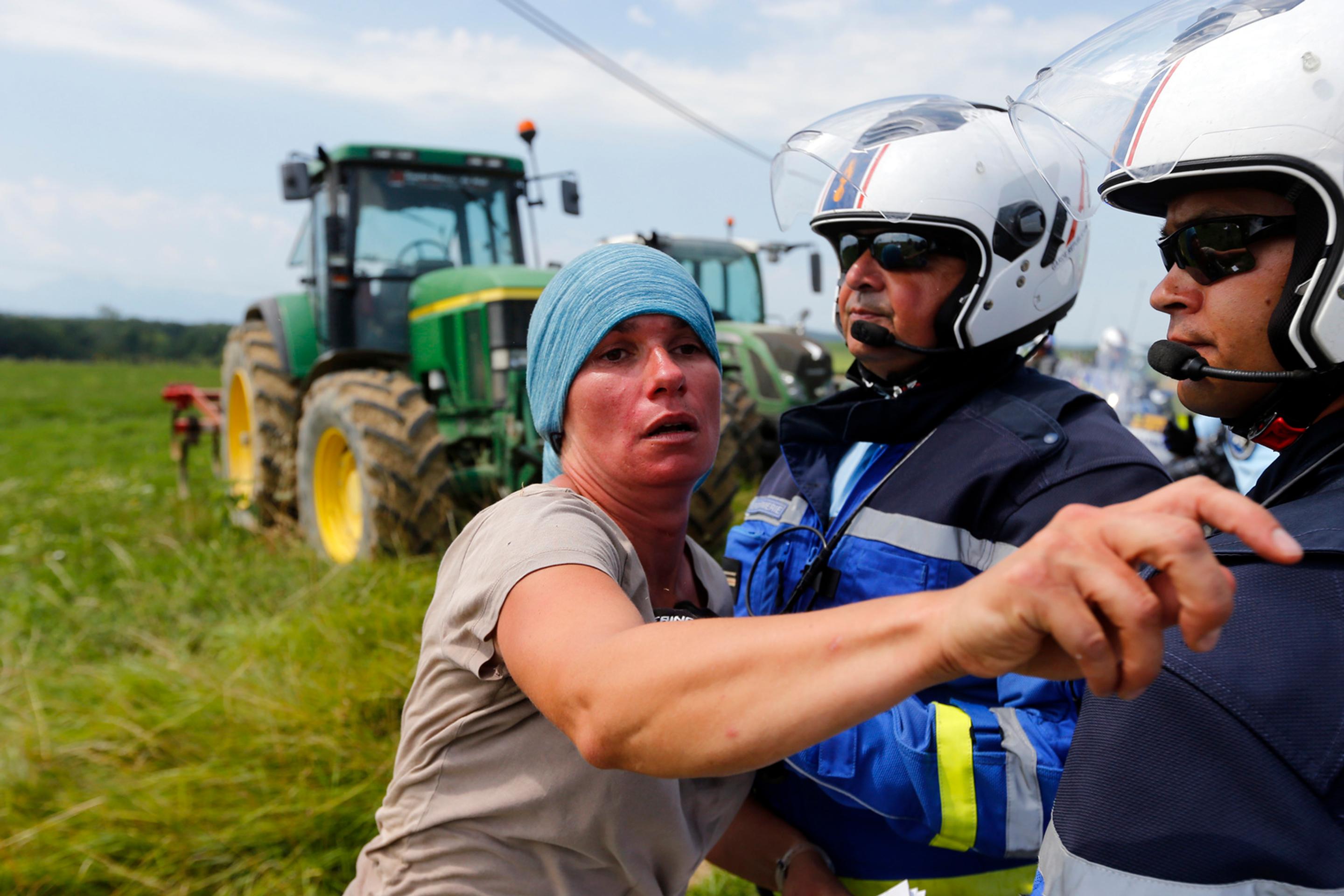 Polícia zatýka ženu počas protestov farmárov na 16. etape Tour de France.