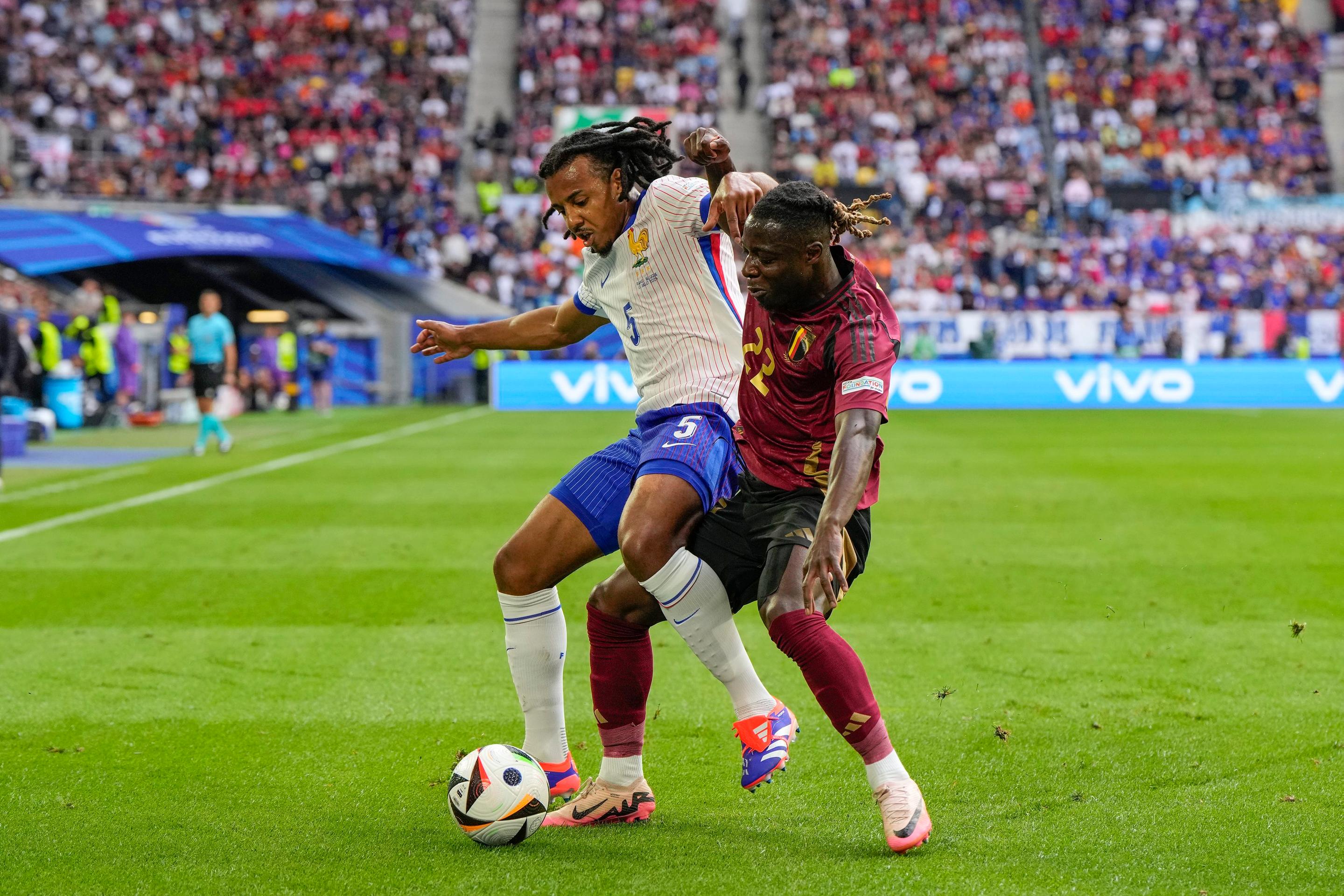 Zľava Francúz Jules Koundé v súboji s Jérémym Dokuom z Belgicka v osemfinále ME 2024.