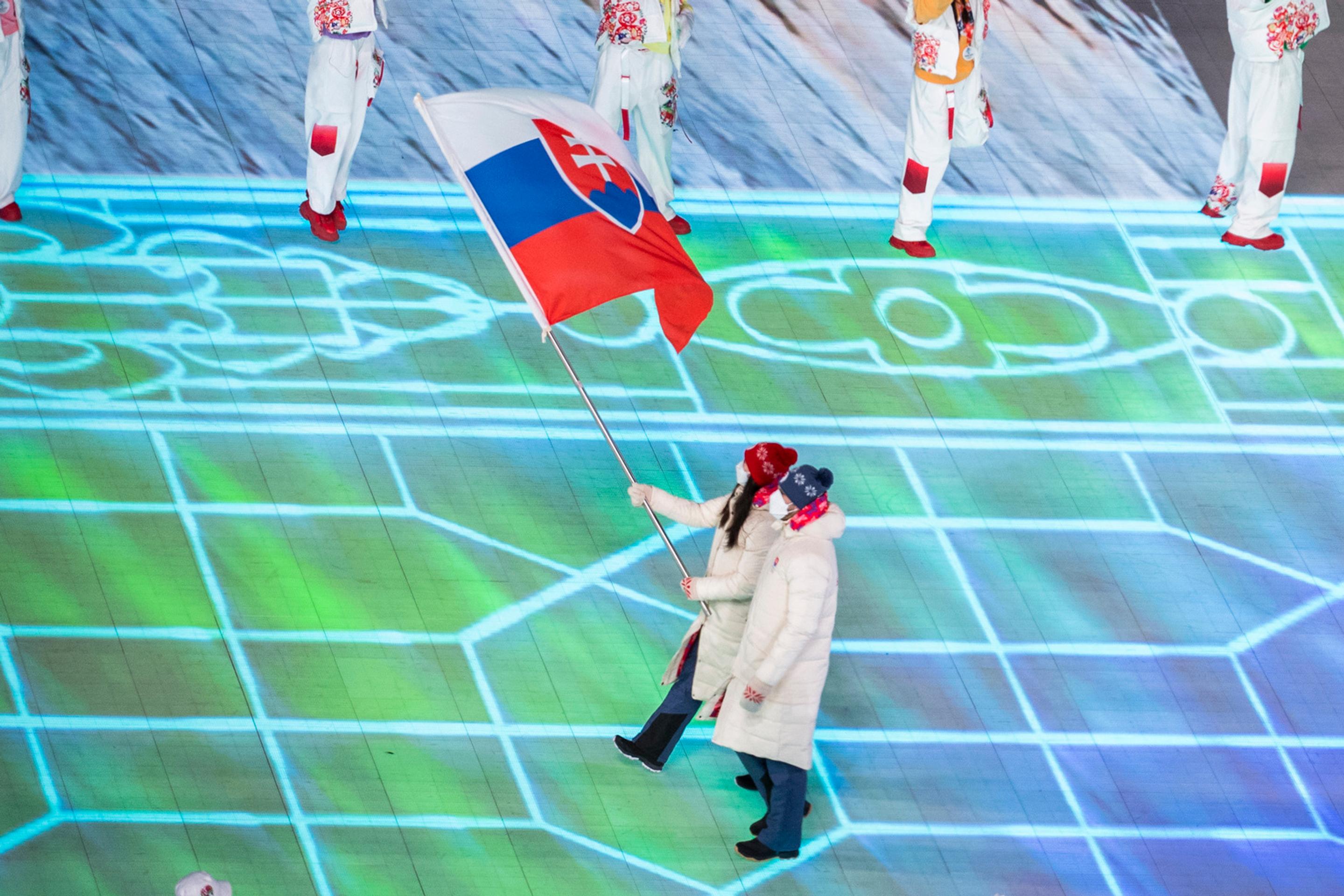 Vlajkonosiči slovenskej výpravy - hokejista Marek Hrivík a sánkarka Katarína Šimoňáková počas otváracieho ceremoniálu ZOH 2022.