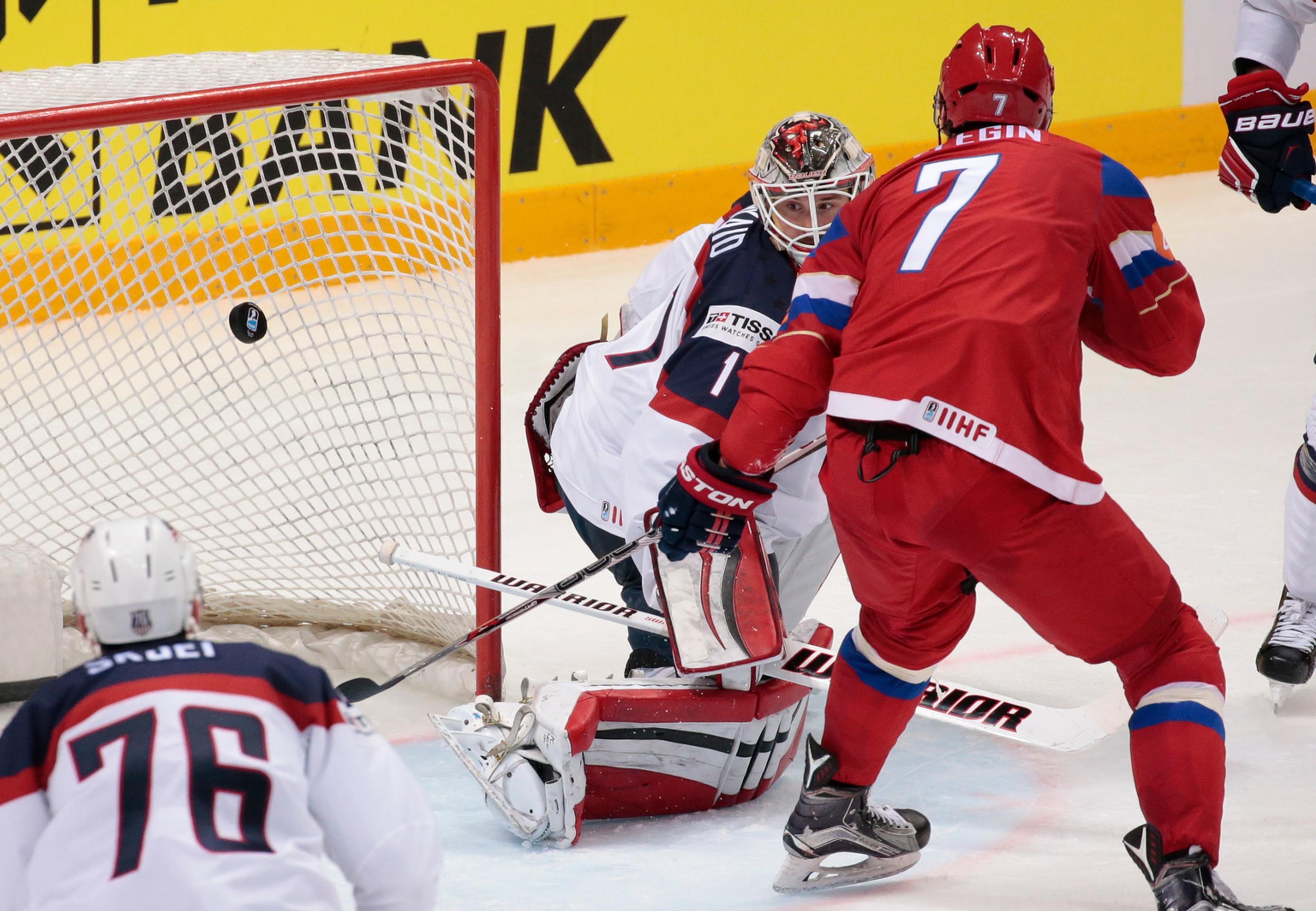 Ivan Telegin z Ruska strieľa štvrtý gól brankárovi USA Keithovi Kinkaidovi (v strede) v zápase o tretie miesto na MS v Rusku