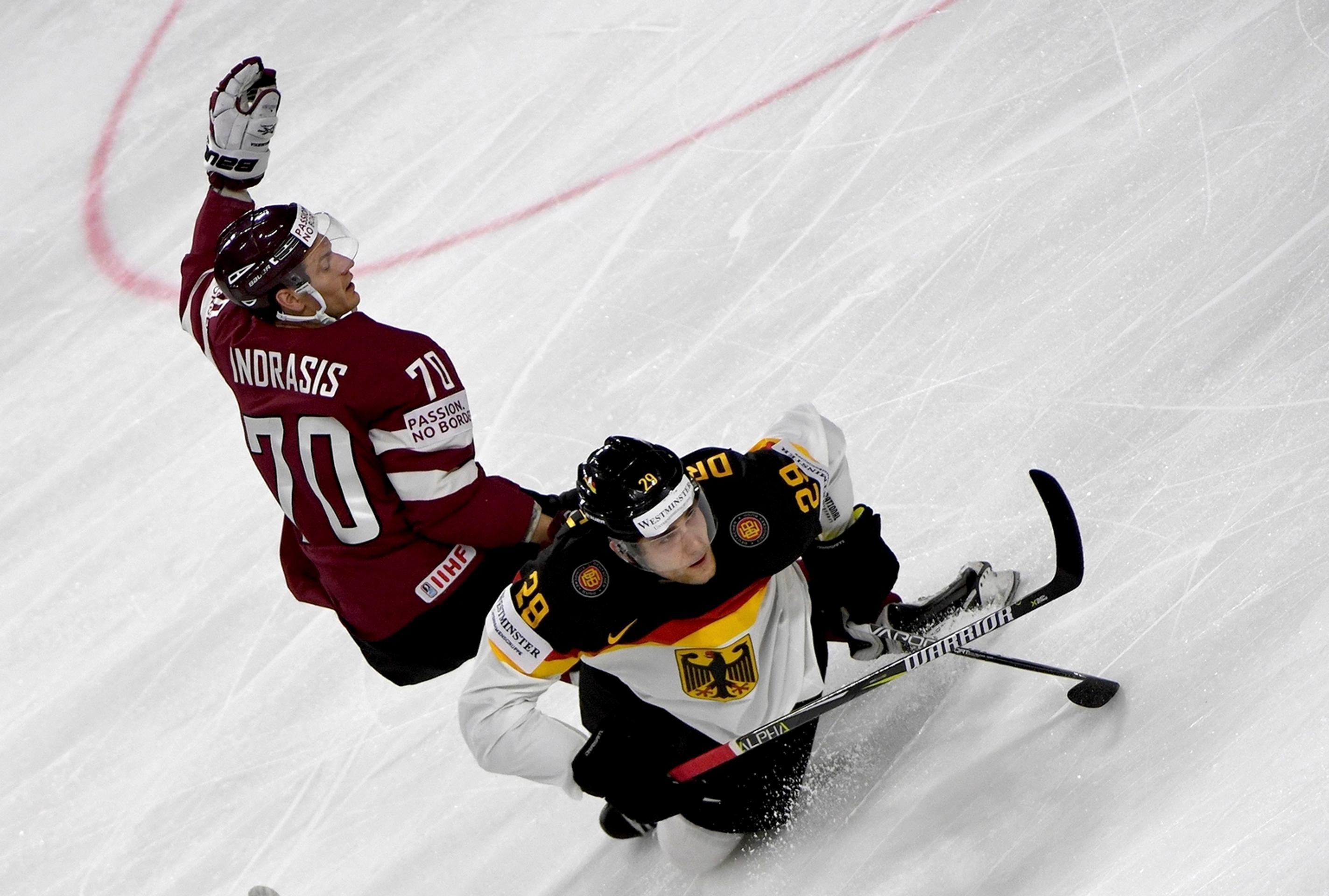 Lotyš Miks Indrašis (vľavo) atakuje nemeckého útočníka Leona Draisaitla v zápase MS 2017.