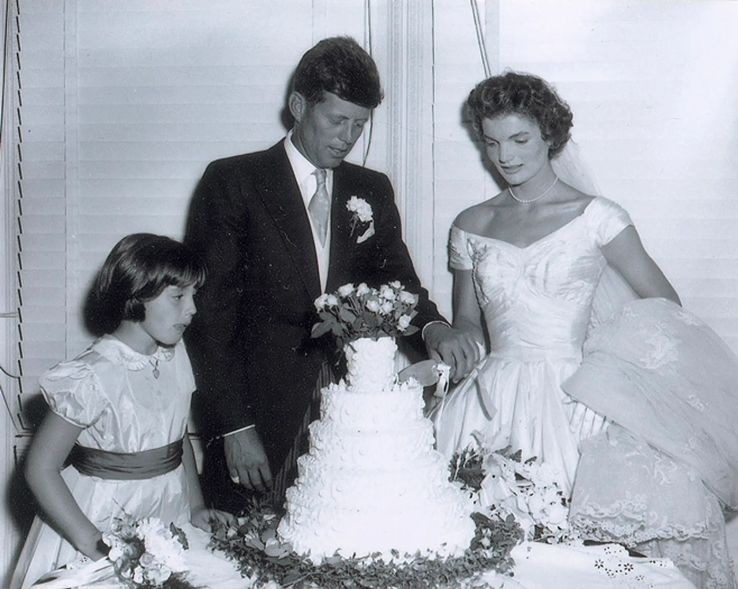 Na archívnej snímke z 12. septembra 1953  John F. Kennedy a manželka Jacqueline krájajú svadobnú tortu.