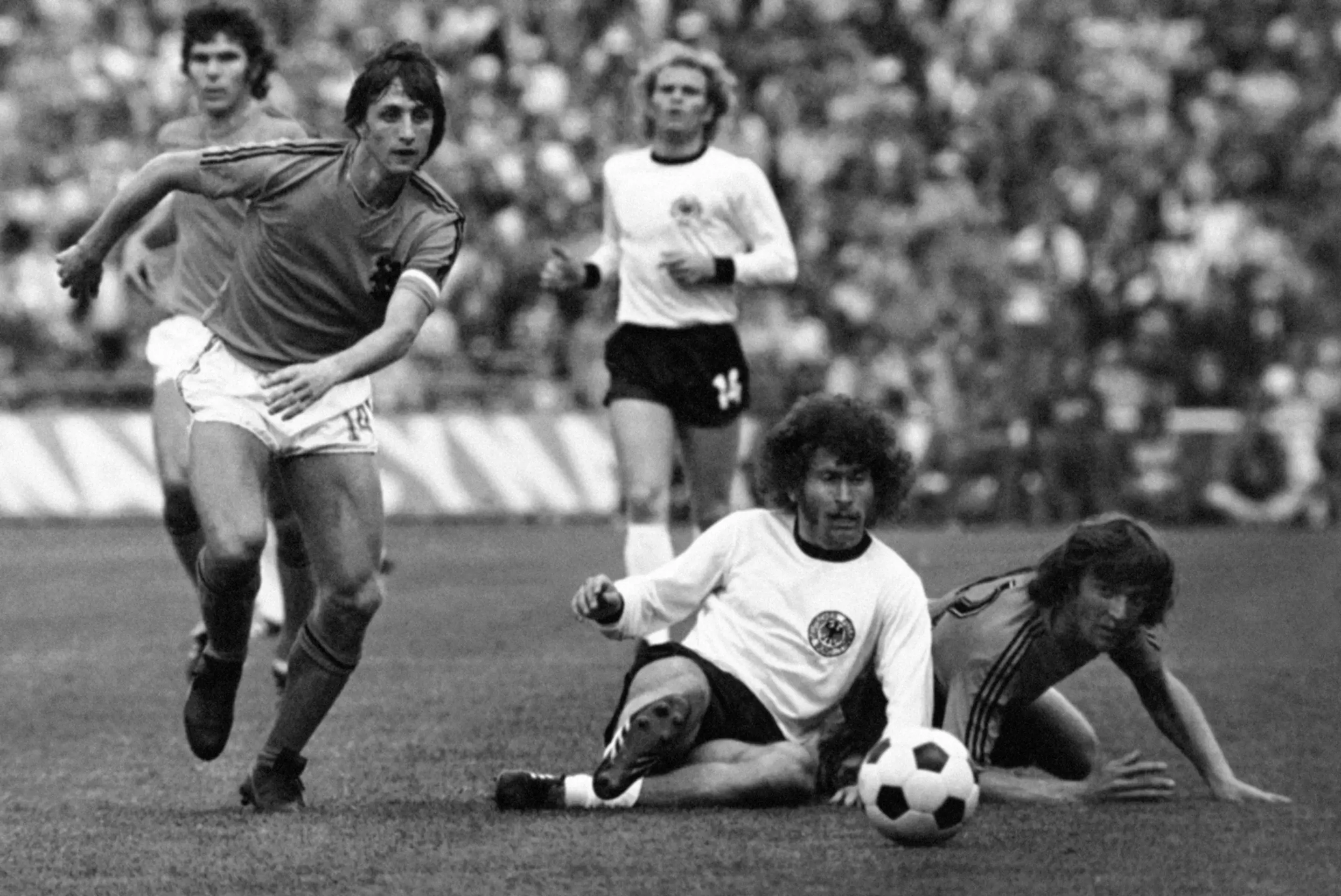 Johan Cruyff (v tmavom drese) uteká za loptou počas finále MS 1974 proti Nemecku.