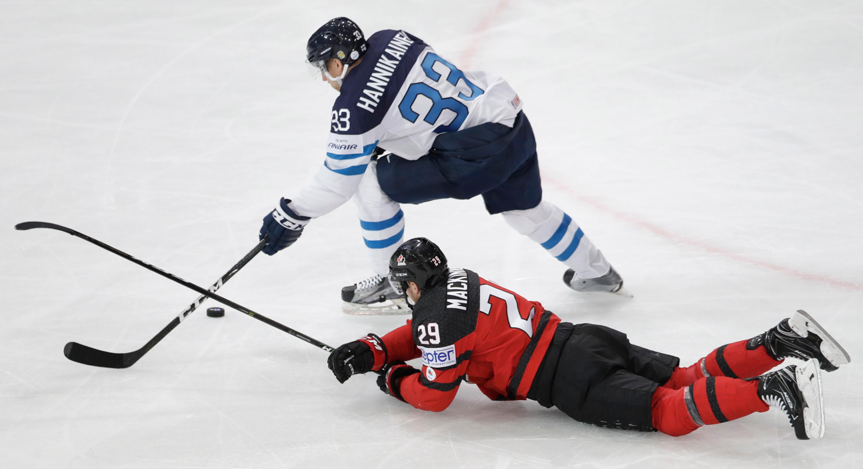 Nathan Mackinnon (dole) z Kanady sa snaží v zápase MS 2017 zastaviť Fína Markusa Hannikainena.