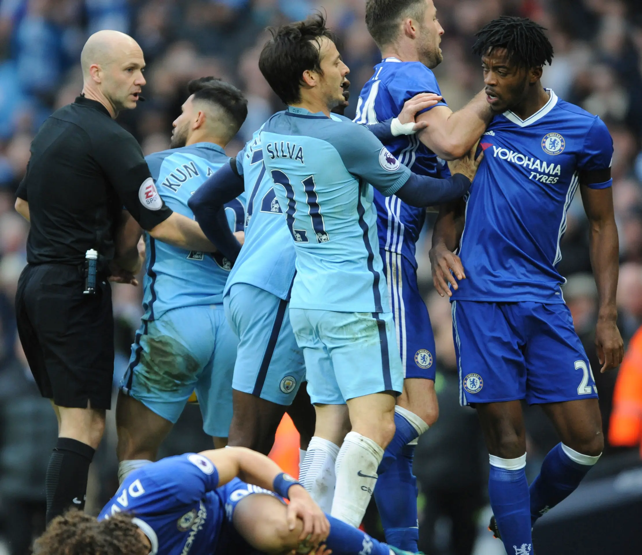 Potýčka v šlágri kola anglickej Premier League medzi Man City a Chelsea, na zemi leží hráč hostí David Luiz.