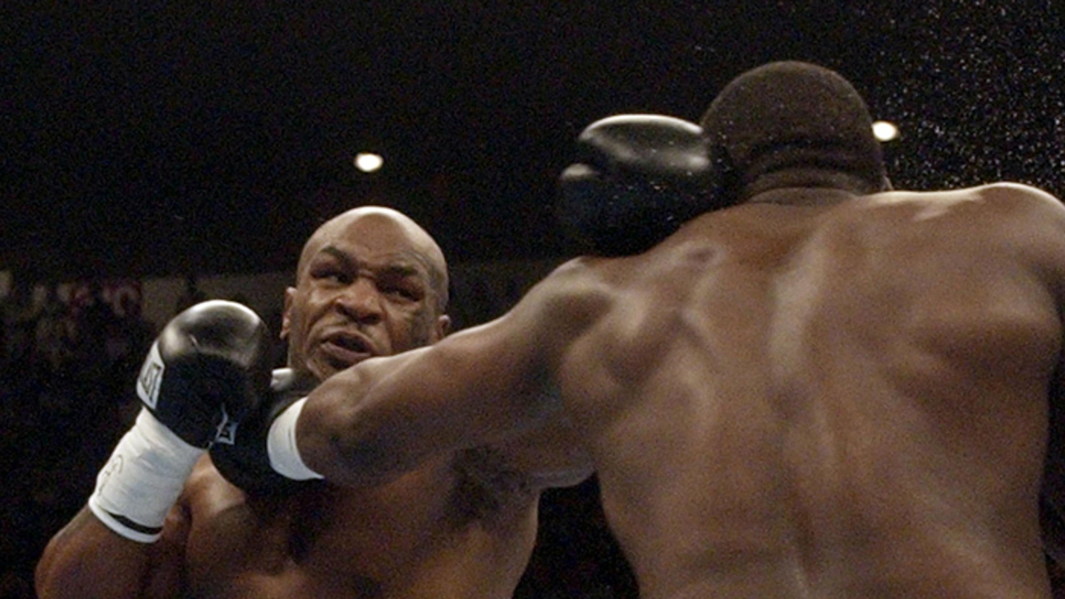 Bývalý svetový šampión v ťažkej váhe Mike Tyson (vľavo) úderom zasahuje Dannyho Williamsa (30. júla 2004).
