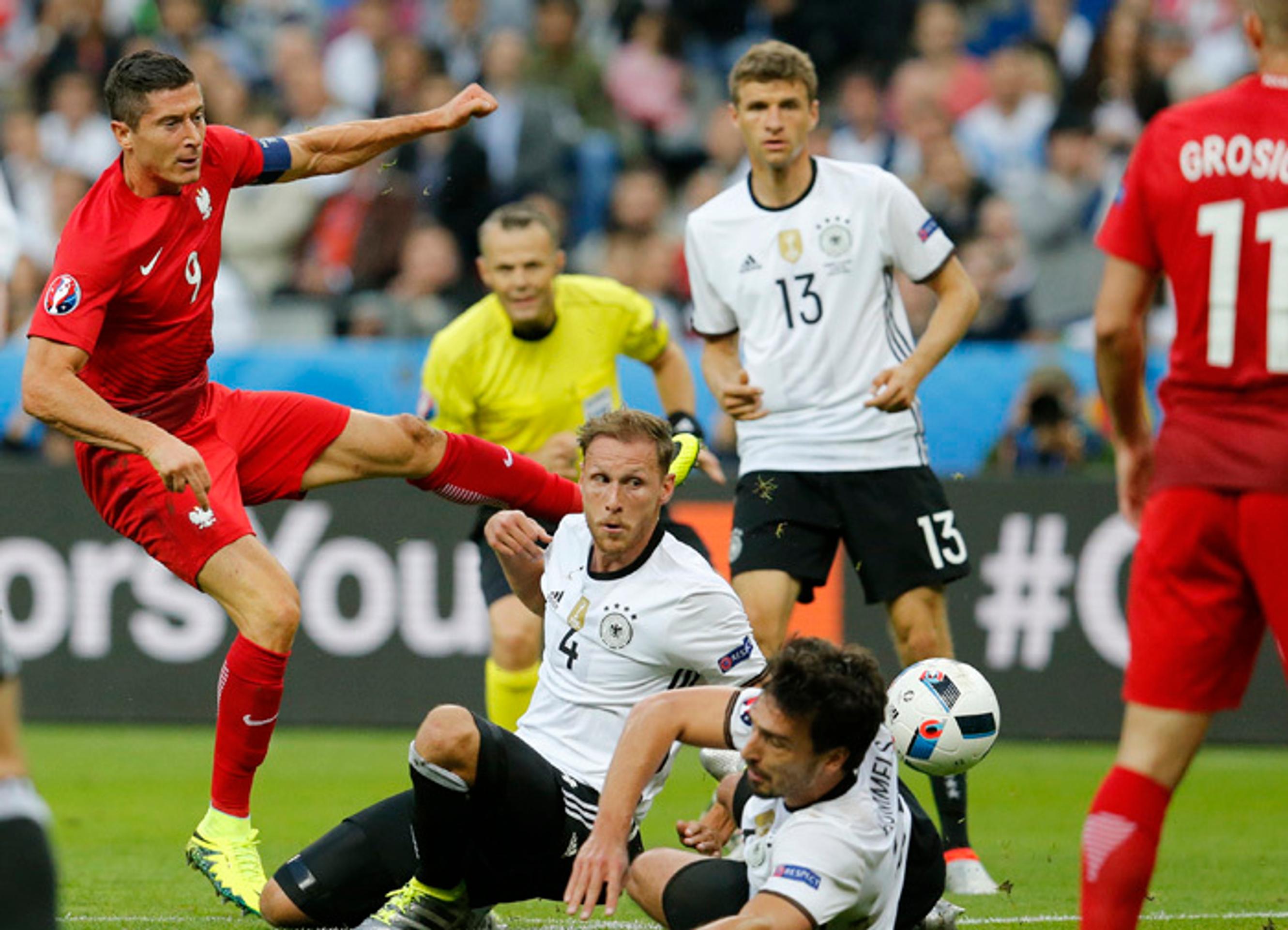 Robert Lewandowski (Poľsko) v súboji o loptu s nemeckými hráčmi v zápase na ME.