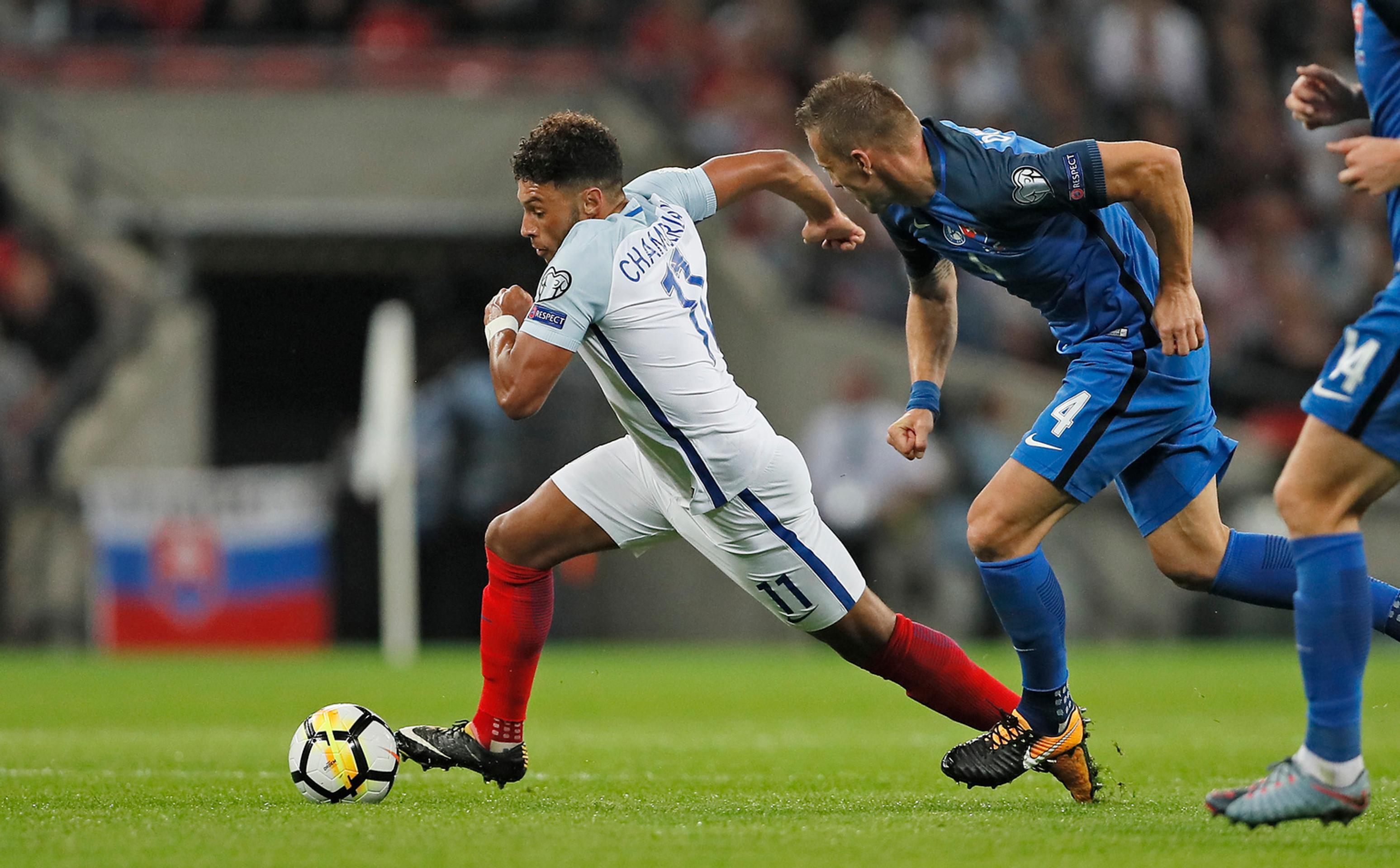 Alex Oxlade-Chamberlain (vľavo) uteká s loptou pred Jánom Ďuricom v kvalifikačnom zápase MS proti Anglicku.