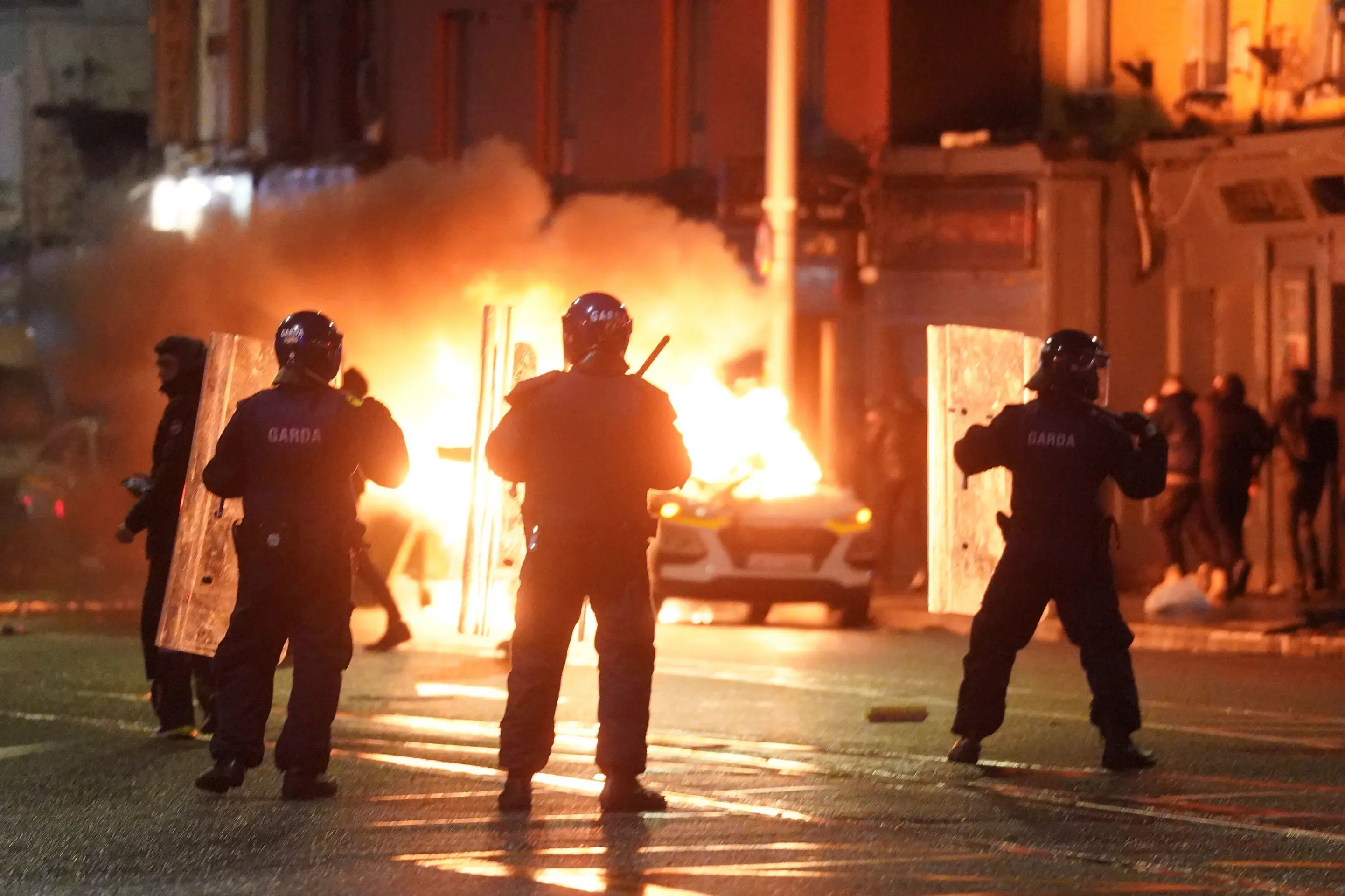 Na snímke auto horí počas demonštrácie na mieste útoku v centre Dublinu
