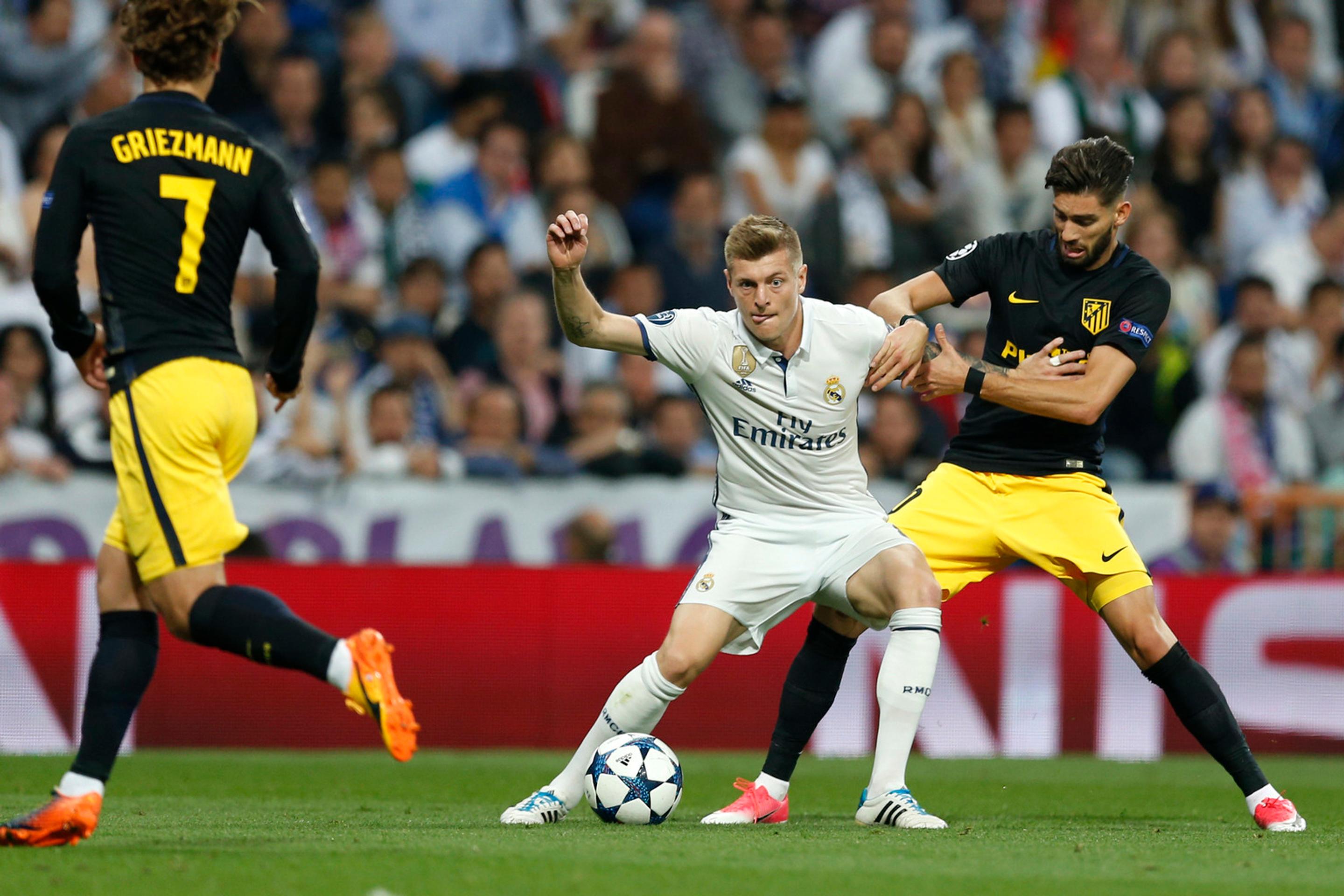 Toni Kroos z Realu bojuje o loptu s Yannickom Carrascom z Atlética v semifinále LM.