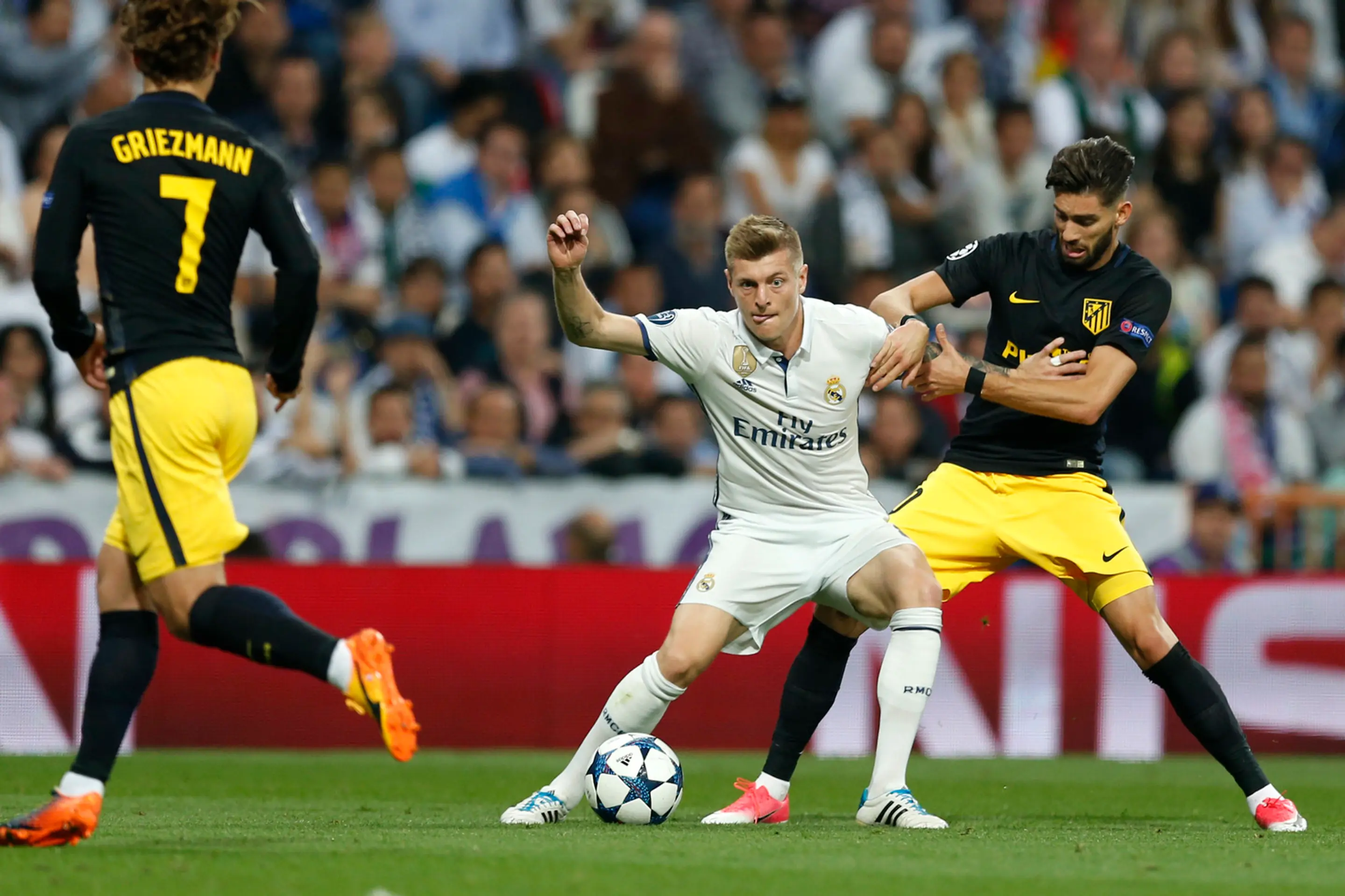 Toni Kroos z Realu bojuje o loptu s Yannickom Carrascom z Atlética v semifinále LM.
