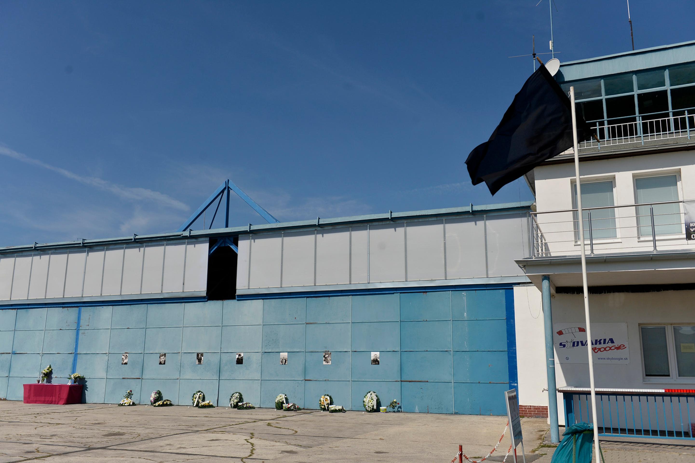 Fotografie obetí leteckého nešťastia na bráne hangára