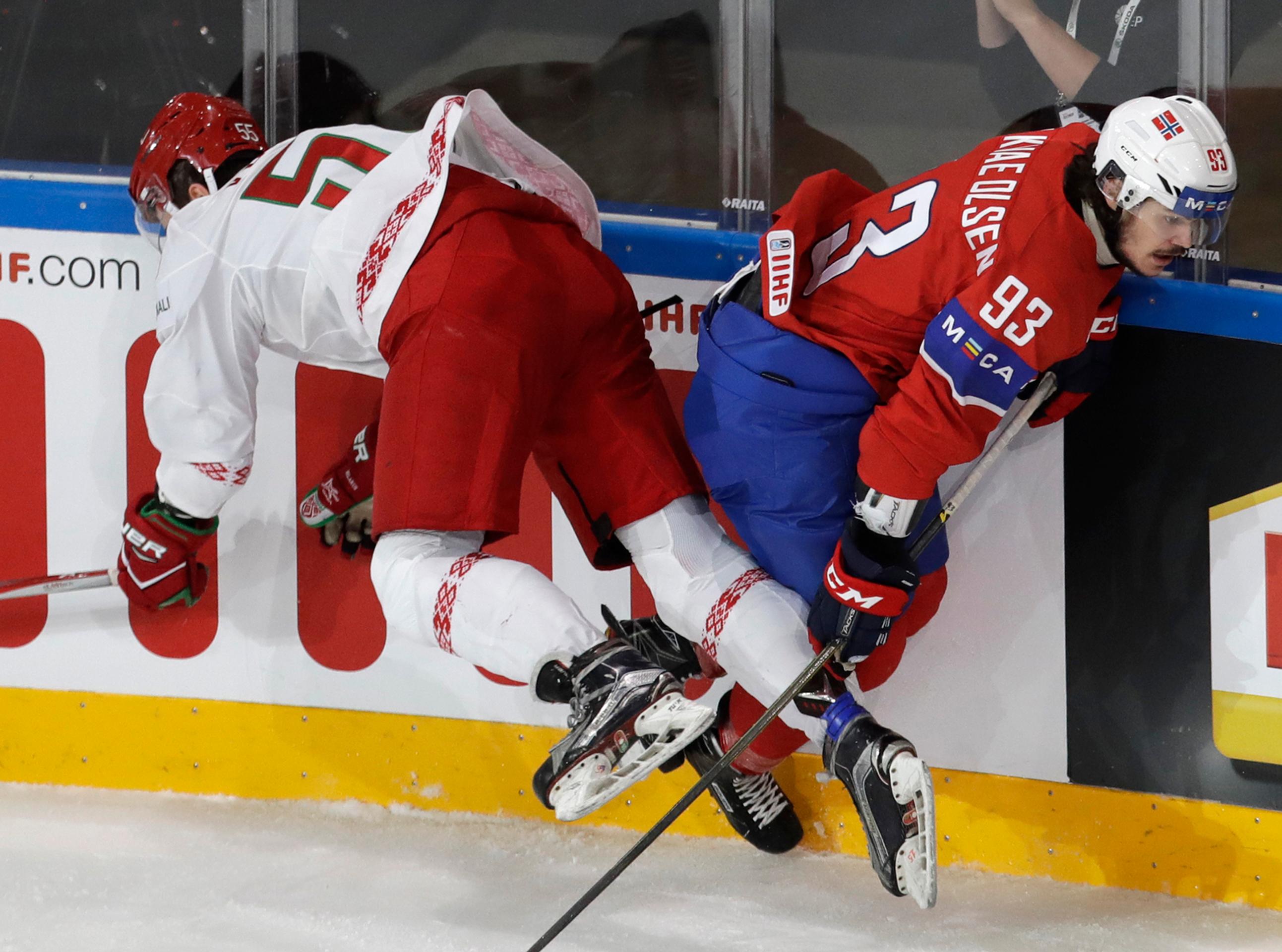 Nór Thomas Valkvä Olsen (vpravo) a Bielorus Pavel Vorobej v súboji o puk.