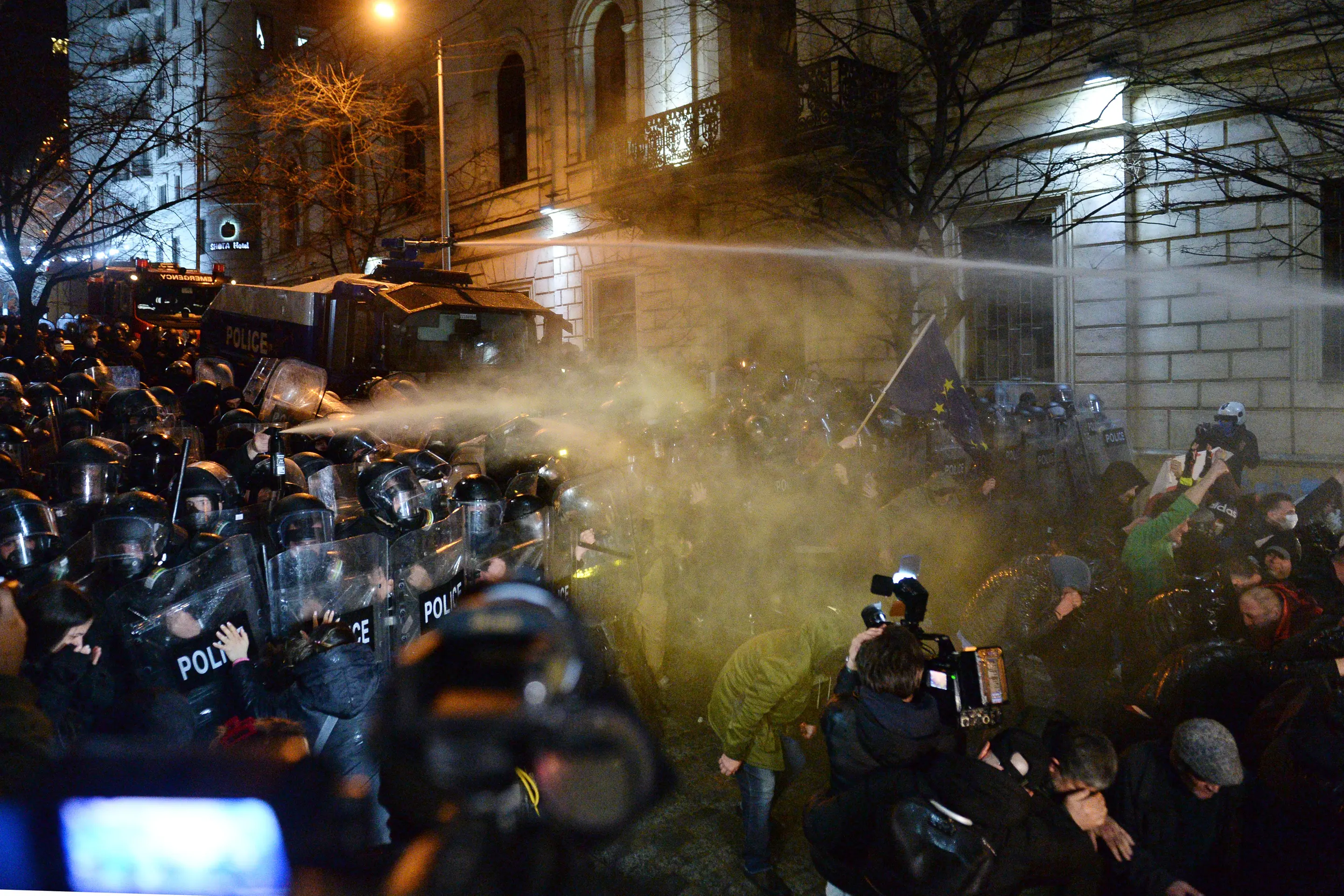 Policajti používajú vodné delá a slzotvorný plyn na demonštrantov, ktorí protestujú pred budovou parlamentu v Tbilisi.