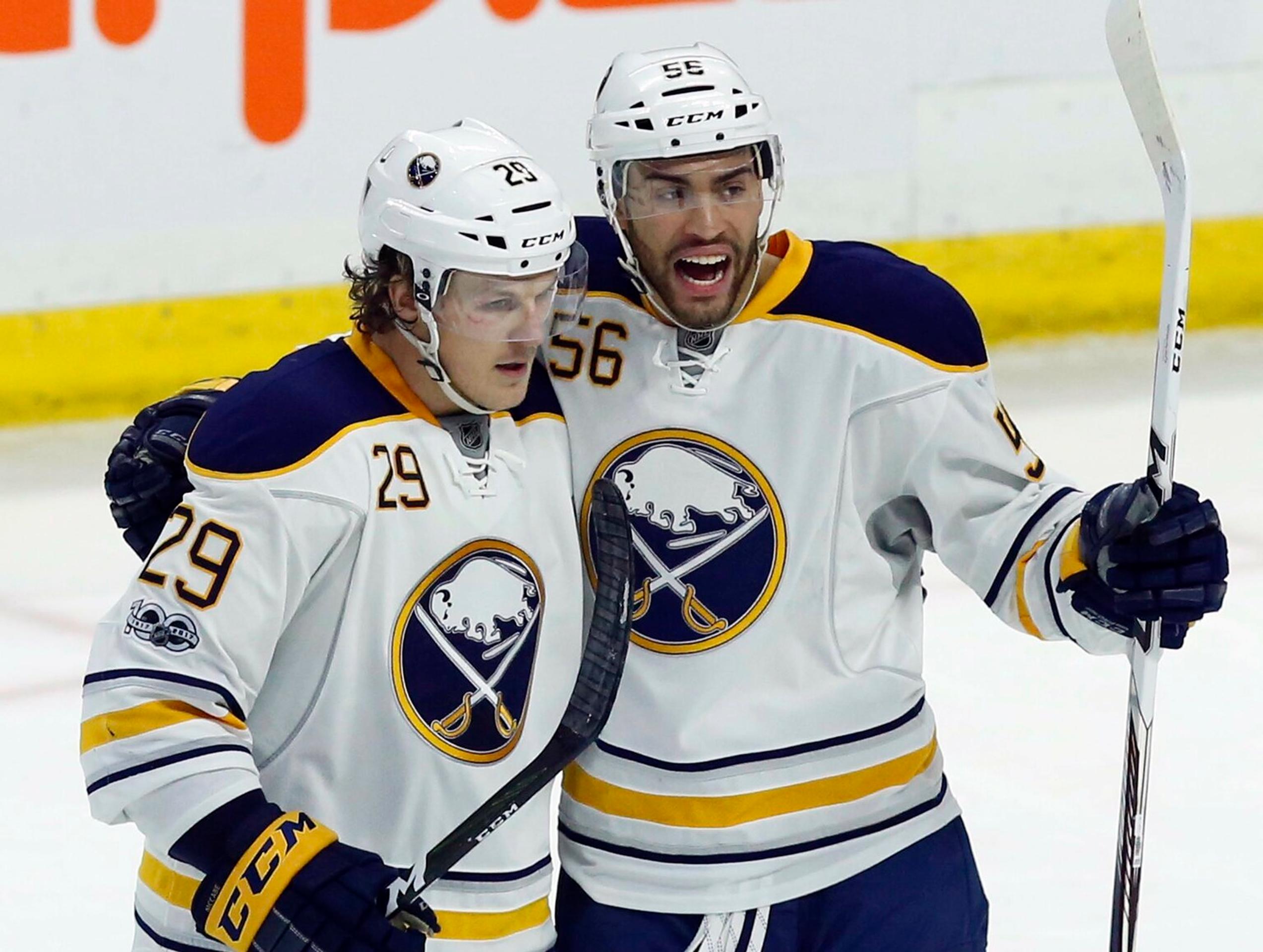 Justin Bailey (číslo 56) z Buffala oslavuje gól so spoluhráčom Jakeom McCabeom proti Ottawe.