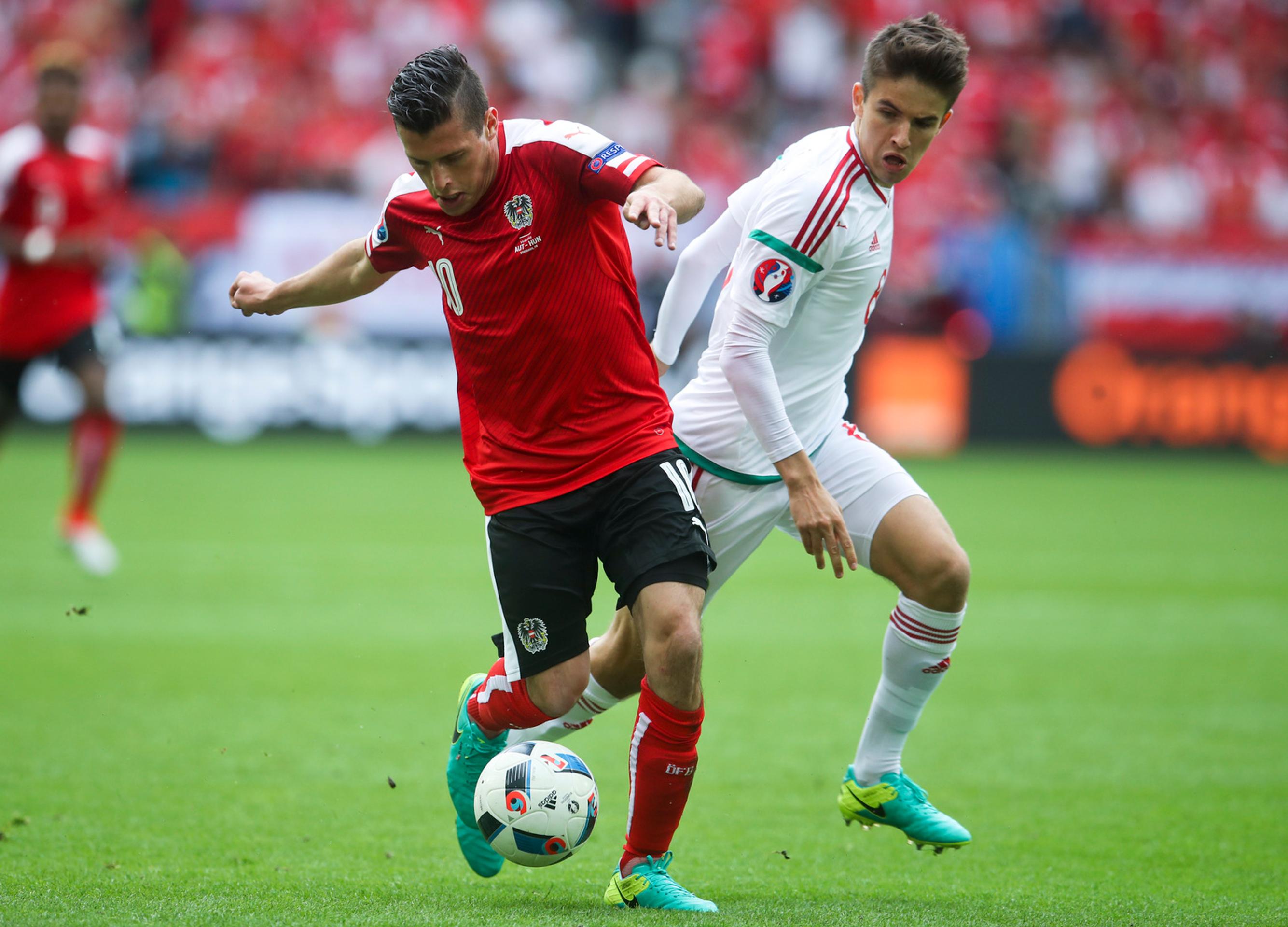 Rakúsky futbalista Zlatko Junuzovič (vľavo) a hráč Maďarska Ádám Nagy v dueli na ME vo Francúzsku.