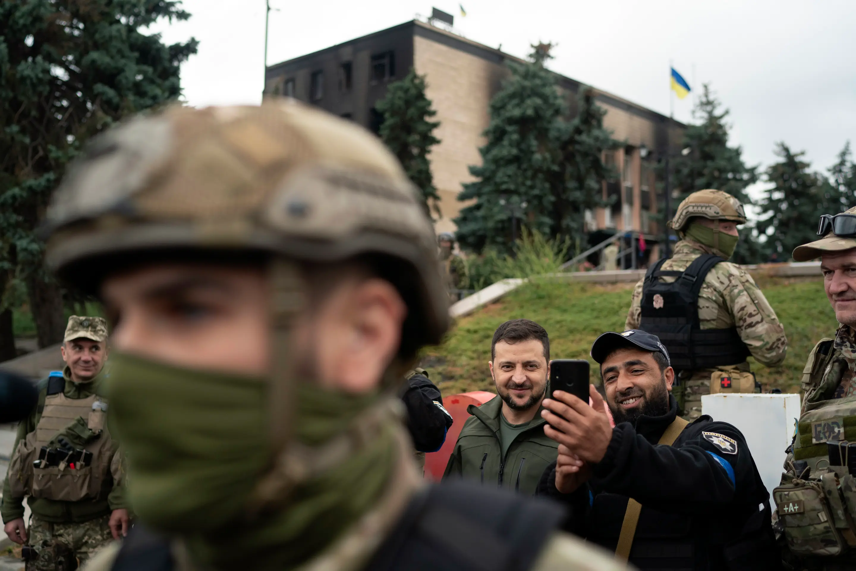 Ukrajinský prezident Volodymyr Zelenskyj pózuje pre selfie s policajtom po vztýčení ukrajinskej vlajky v ukrajinskom meste Izium 14. septembra 2022.