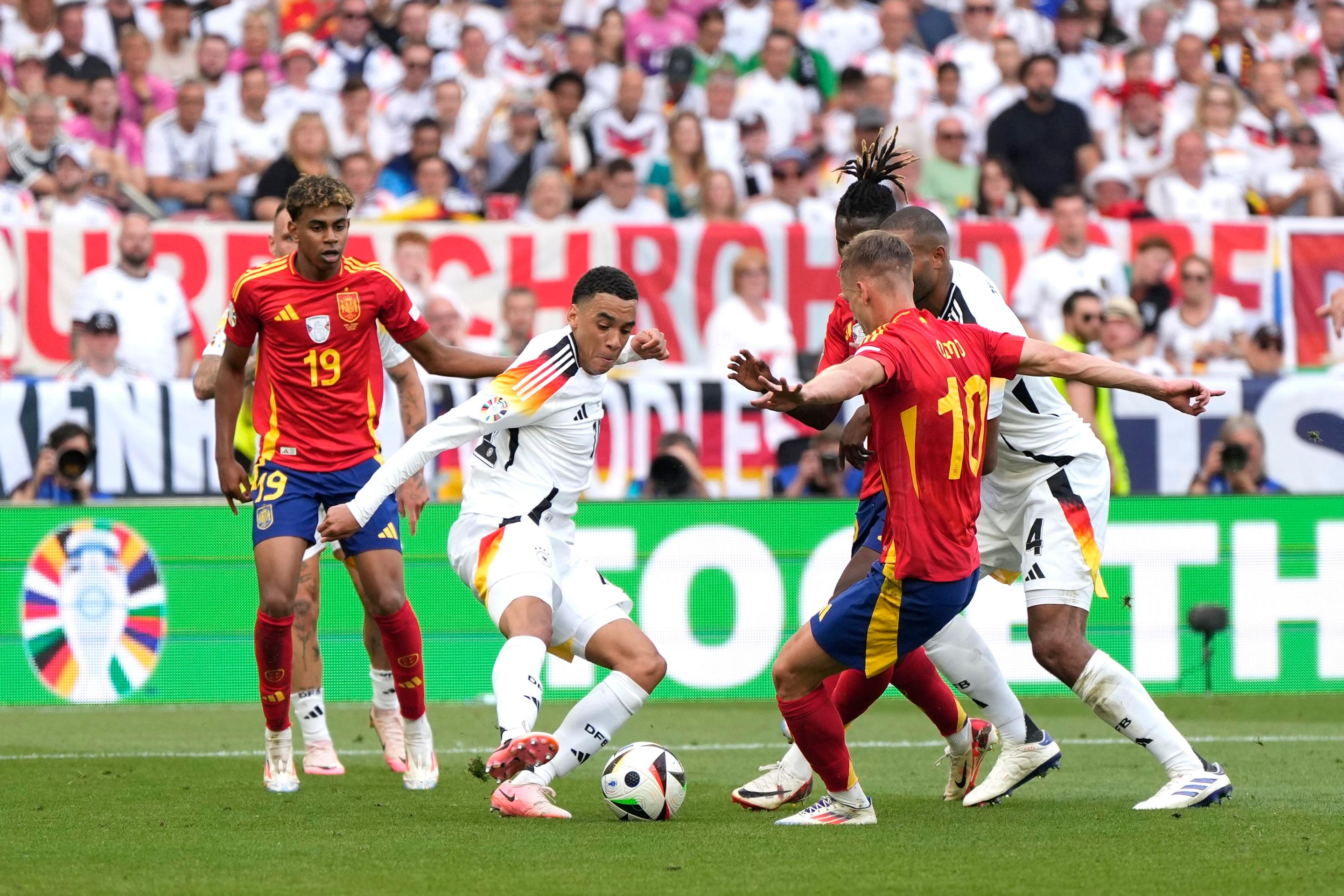 Jamal Musiala v súboji s Danim Olmom.