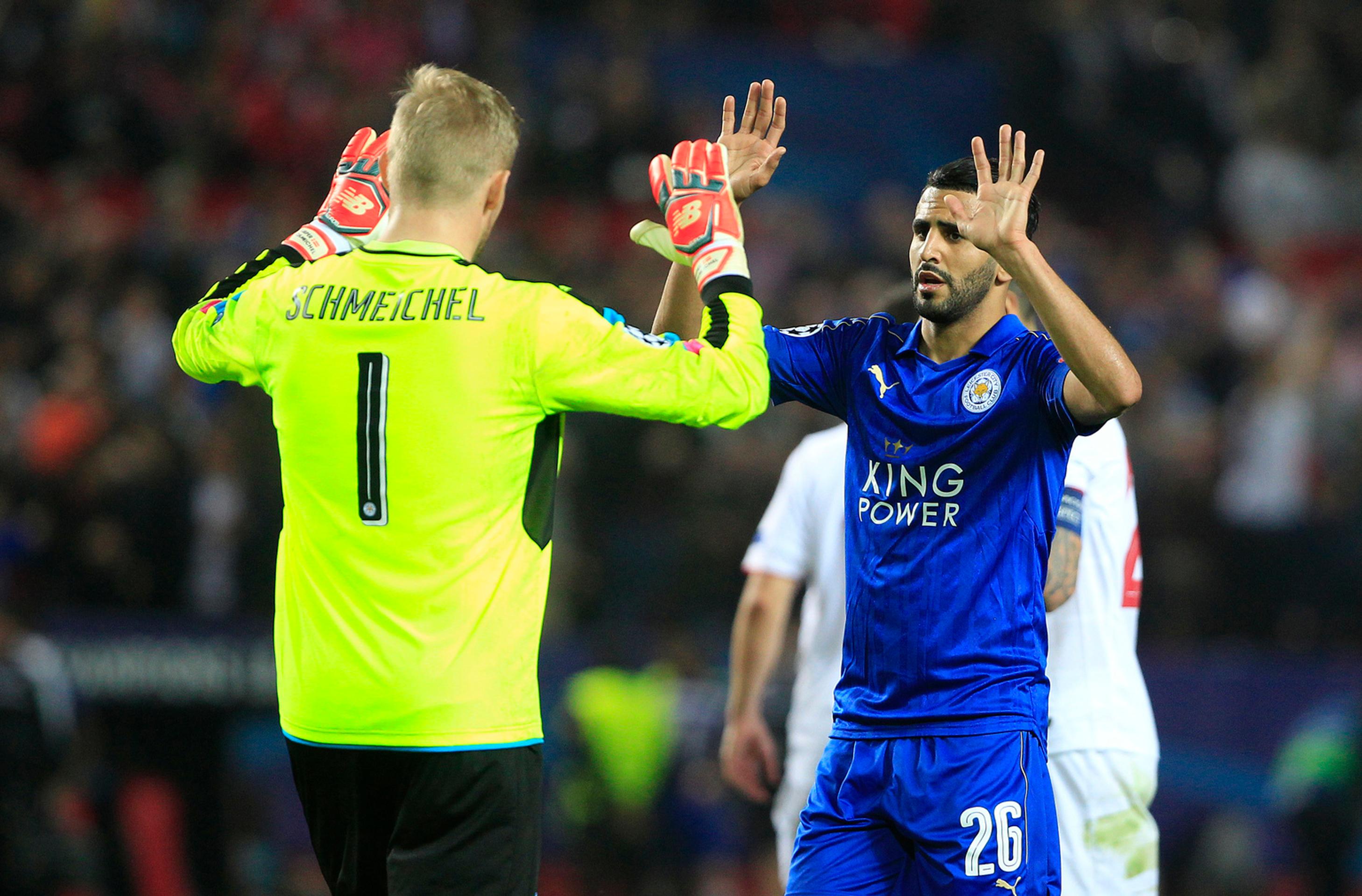 Brankár Leicestru Kasper Schmeichel si podáva ruku so spoluhráčom Riyadom Mahrezom v osemfinále LM proti Seville.