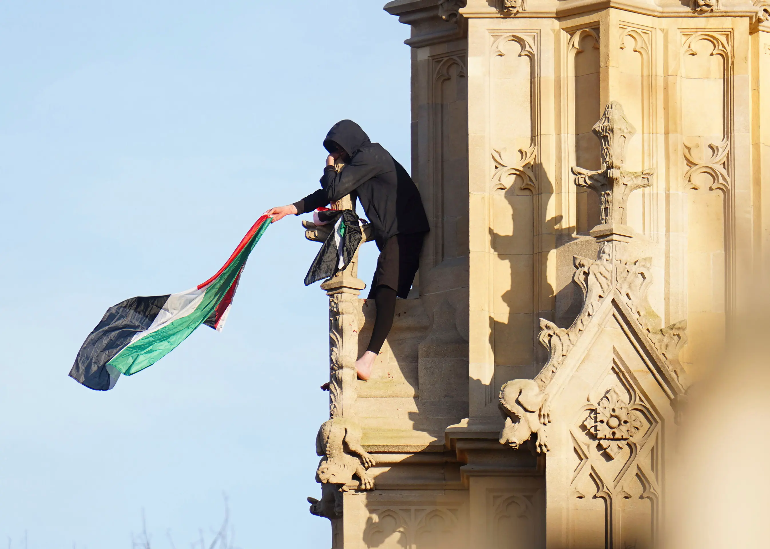 Muž máva s palestínskou vlajkou na Big Bene