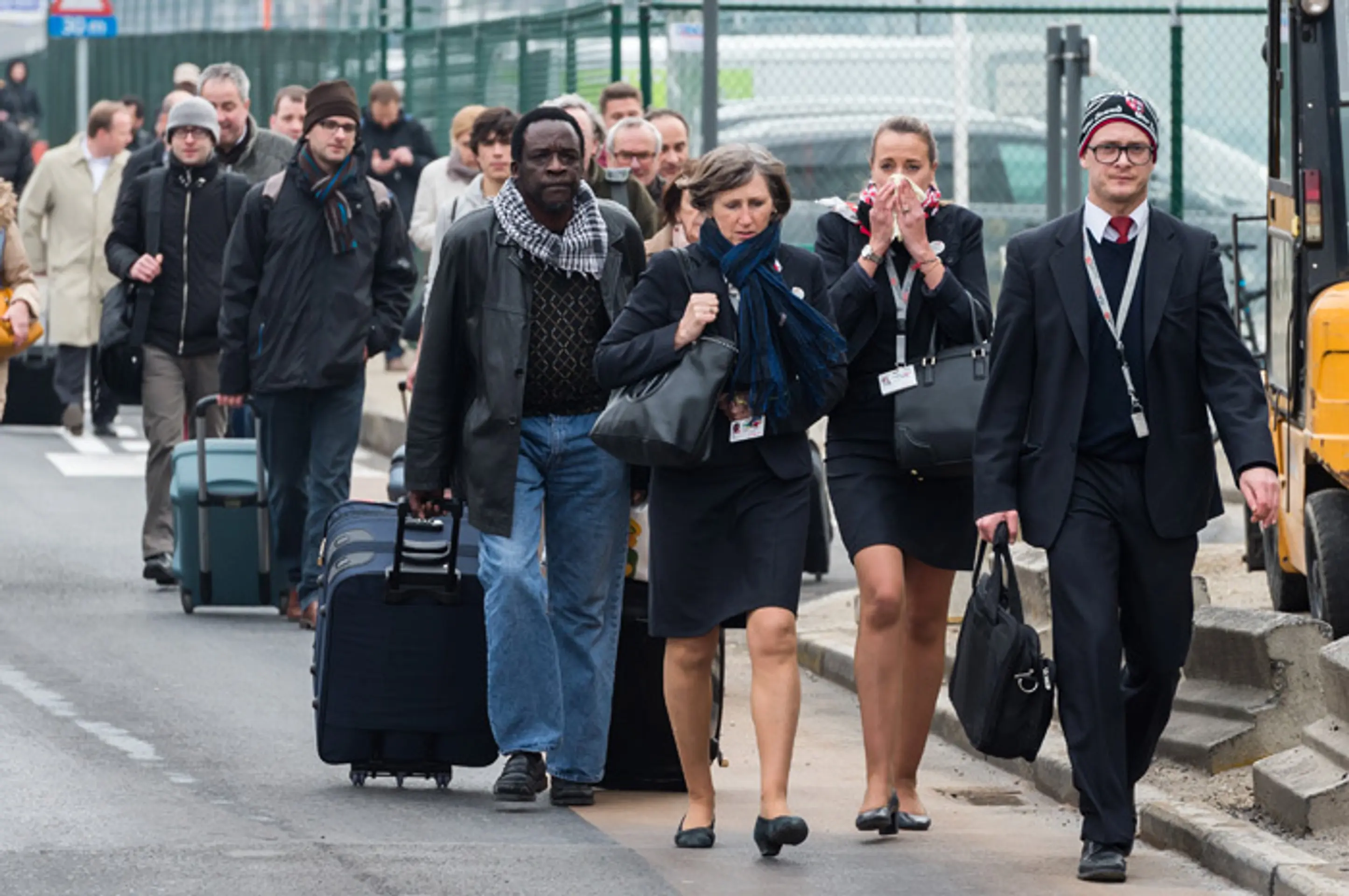 Cestujúci a letecký personál opúšťajú bruselné letisko Zaventem po teroristických výbuchoch.