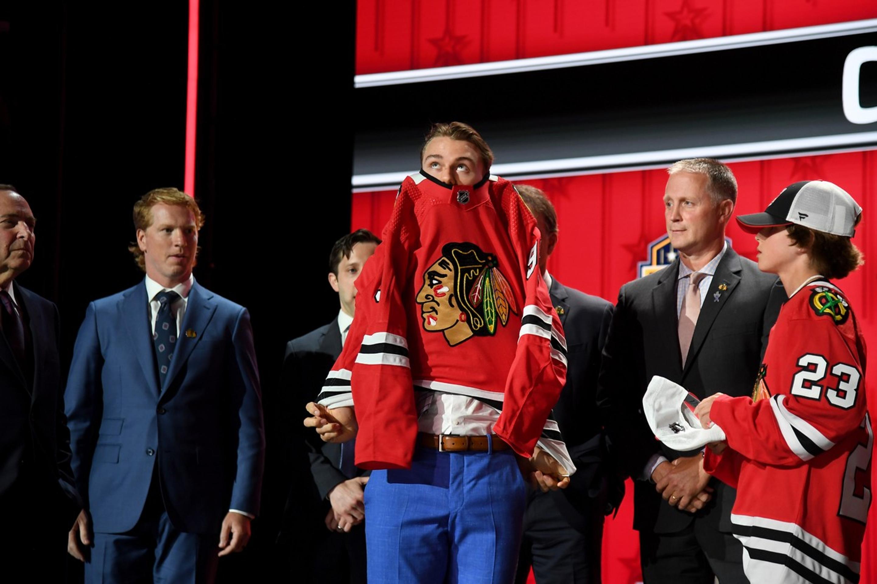 Connor Bedard si oblieka dres Chicaga.