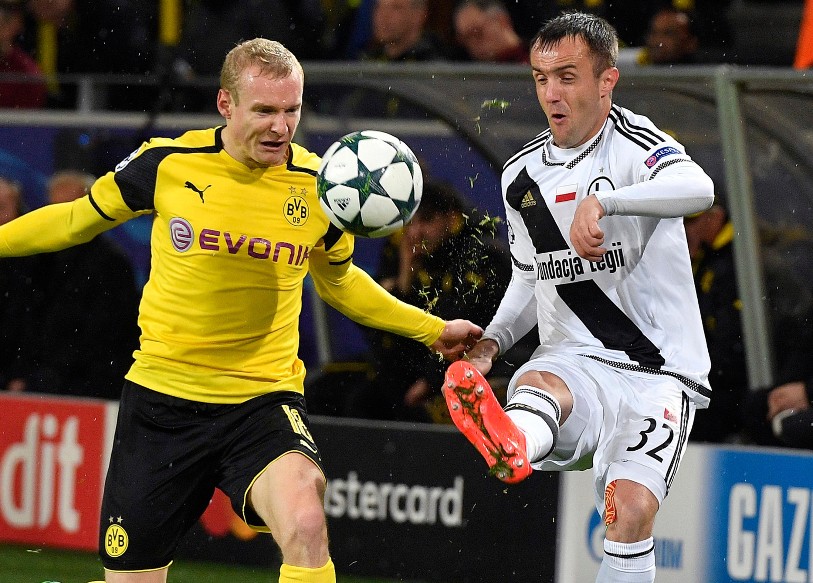 Sebastian Rode z Borussie Dortmund (vľavo) sa snaží získať loptu pred Miroslavom Radovičom z Legie Varšava v dueli LM.