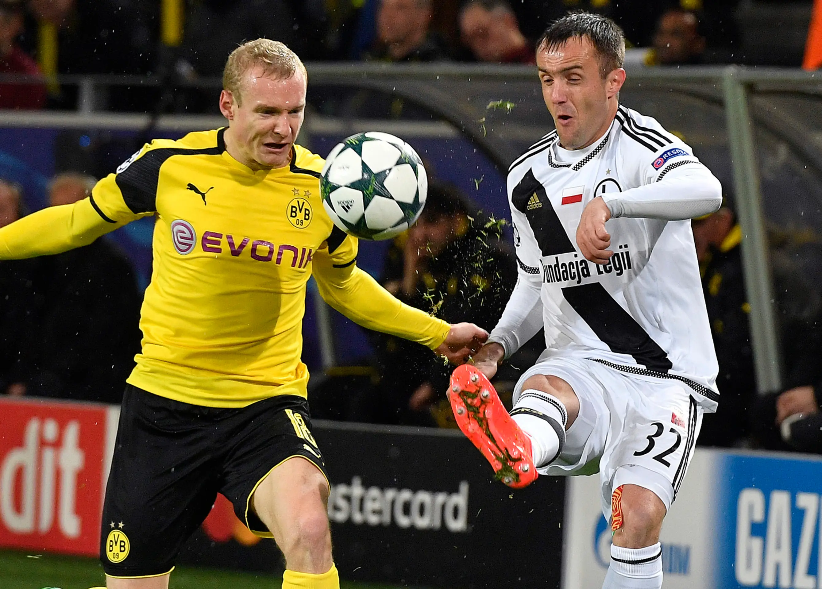 Sebastian Rode z Borussie Dortmund (vľavo) sa snaží získať loptu pred Miroslavom Radovičom z Legie Varšava v dueli LM.