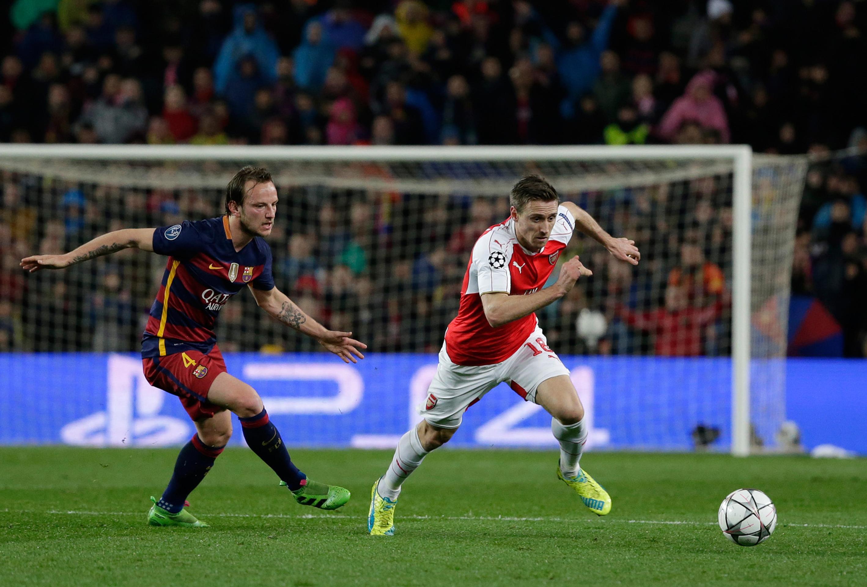 Súboj hráčov FC Barcelona Ivana Rakitiča a Arsenalu Londýn Nacha Monreala.