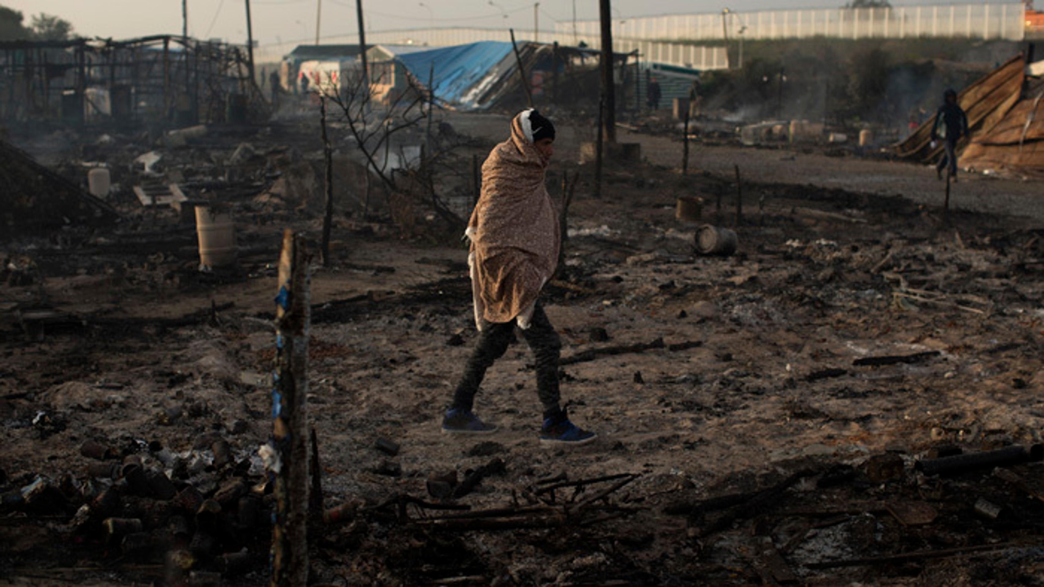 Migranti opúšťajú tábor v Calais.