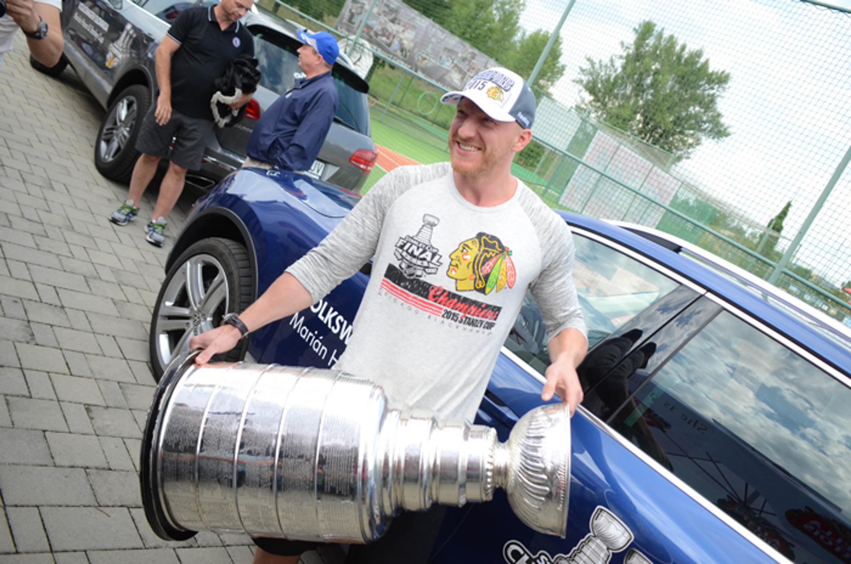 Útočník Chicago Blackhawks Marián Hossa nesie Stanleyho pohár pre víťaza NHL.