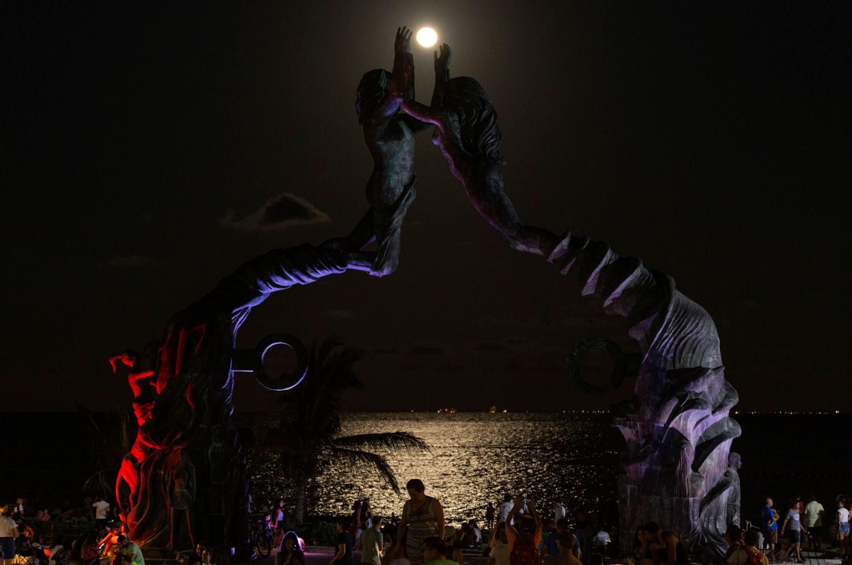 Turisti sledujú zatmenie Mesiaca v mexickom letovisku Parque Fundadores.