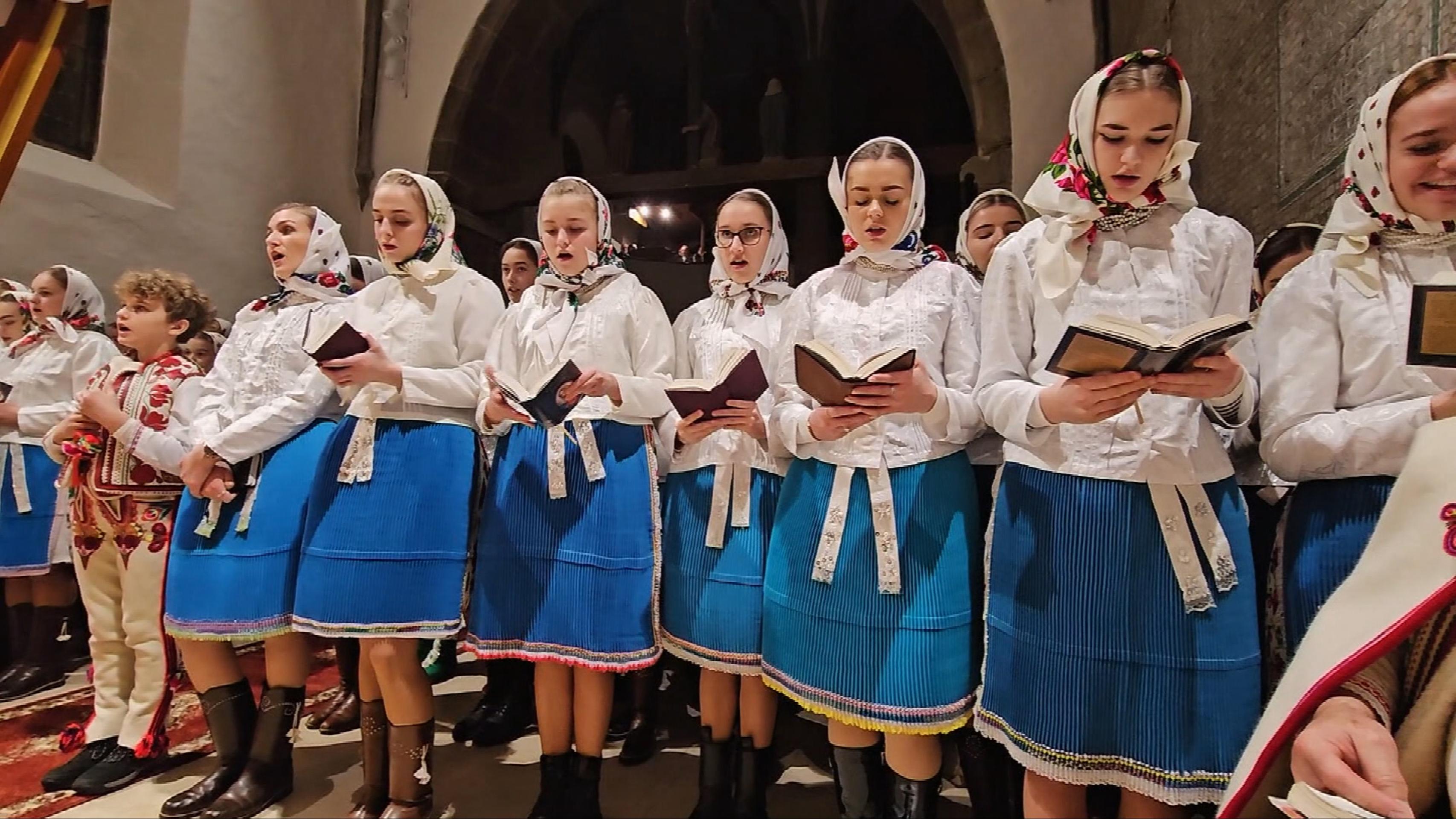 Dievčatá v tradičných krojoch spievajú vianočné piesne.
