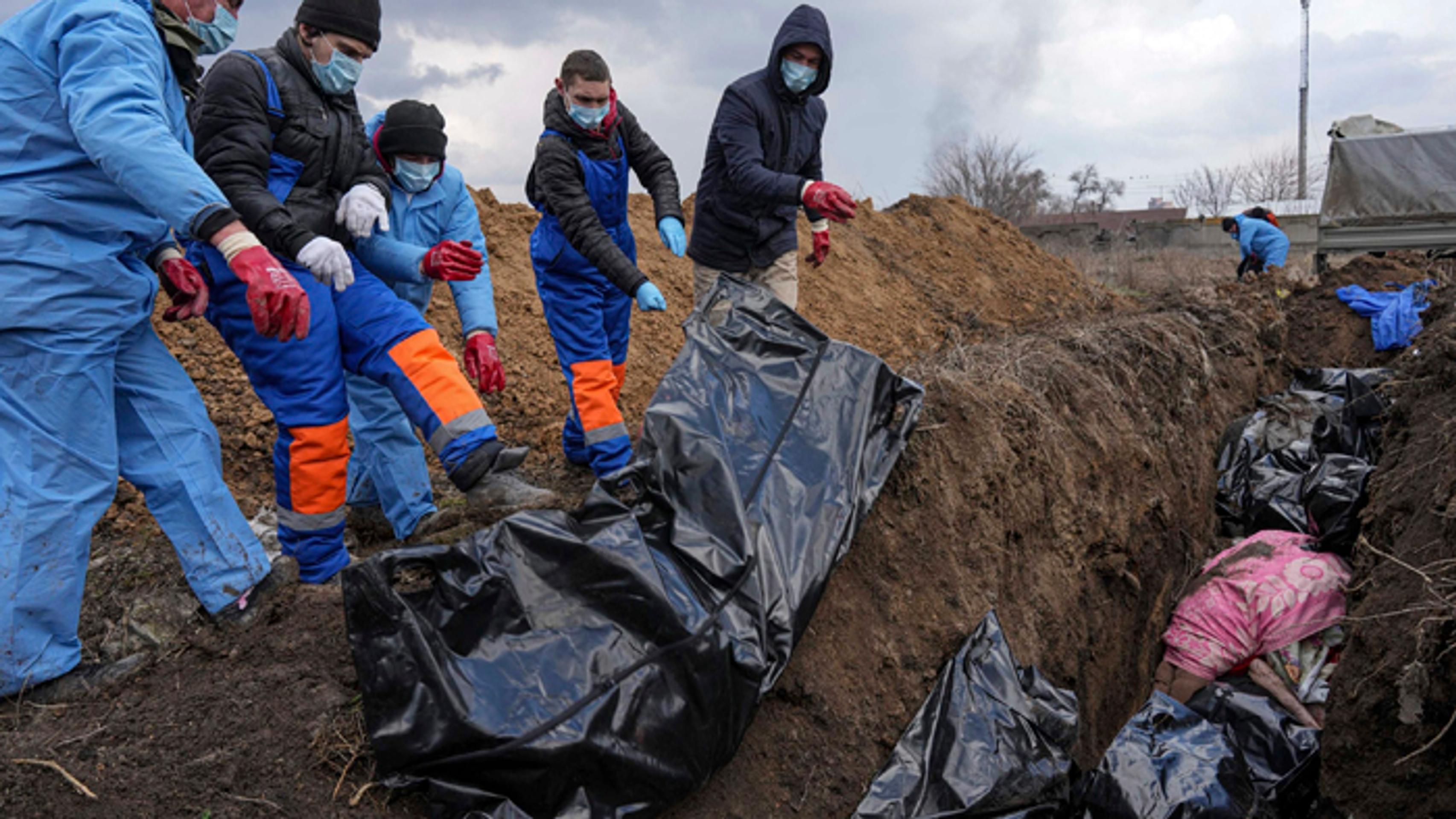 Mŕtve telá ukladujú do masového hrobu v Mariupole.