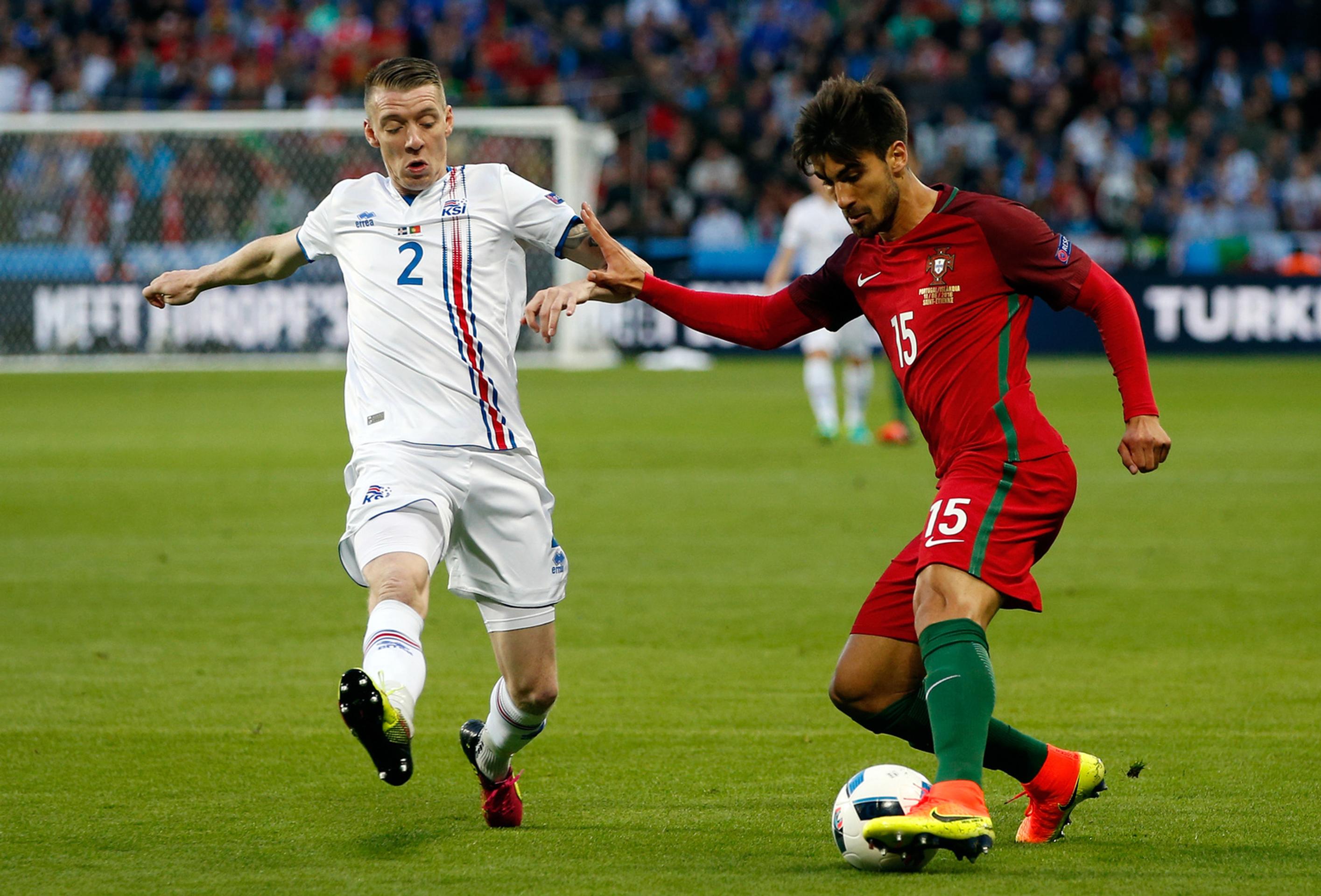 Portulčan Andre Gomes (vpravo) v obkľúčení Islanďana Birkira Saevarssona vo vzájomnom dueli na ME vo Francúzsku.