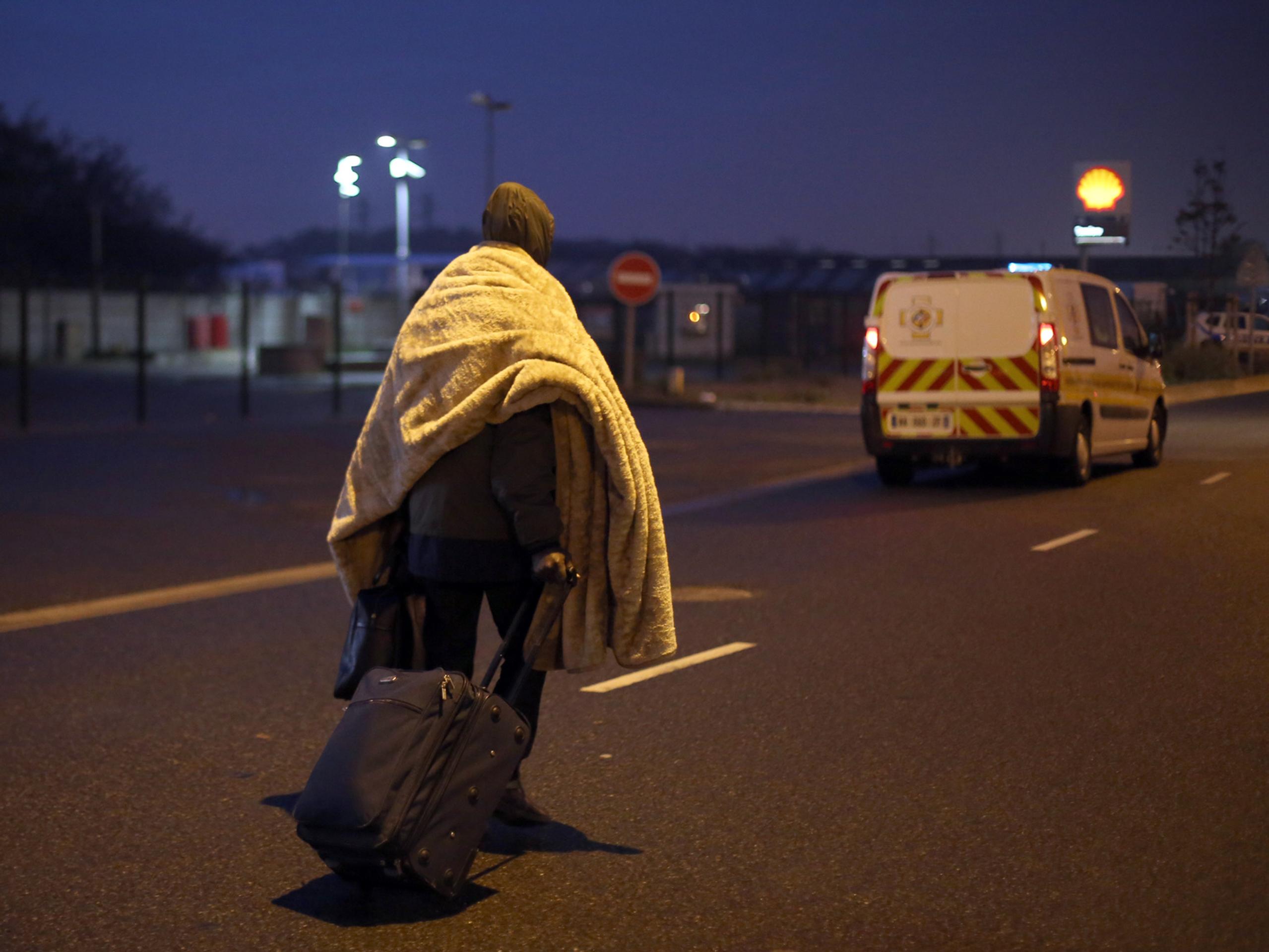 Migrant s batožinou opúšťa utečenecký tábor v severofrancúzskom prístavnom meste Calais, ktorý prezývajú Džungľa.