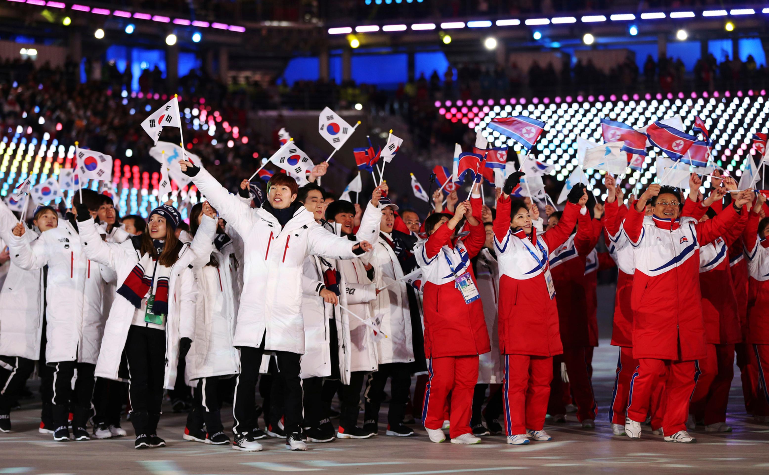 Členovia severo a juhokórejskej olympijskej výpravy mávajú národnými zástavami počas záverečného ceremoniálu.