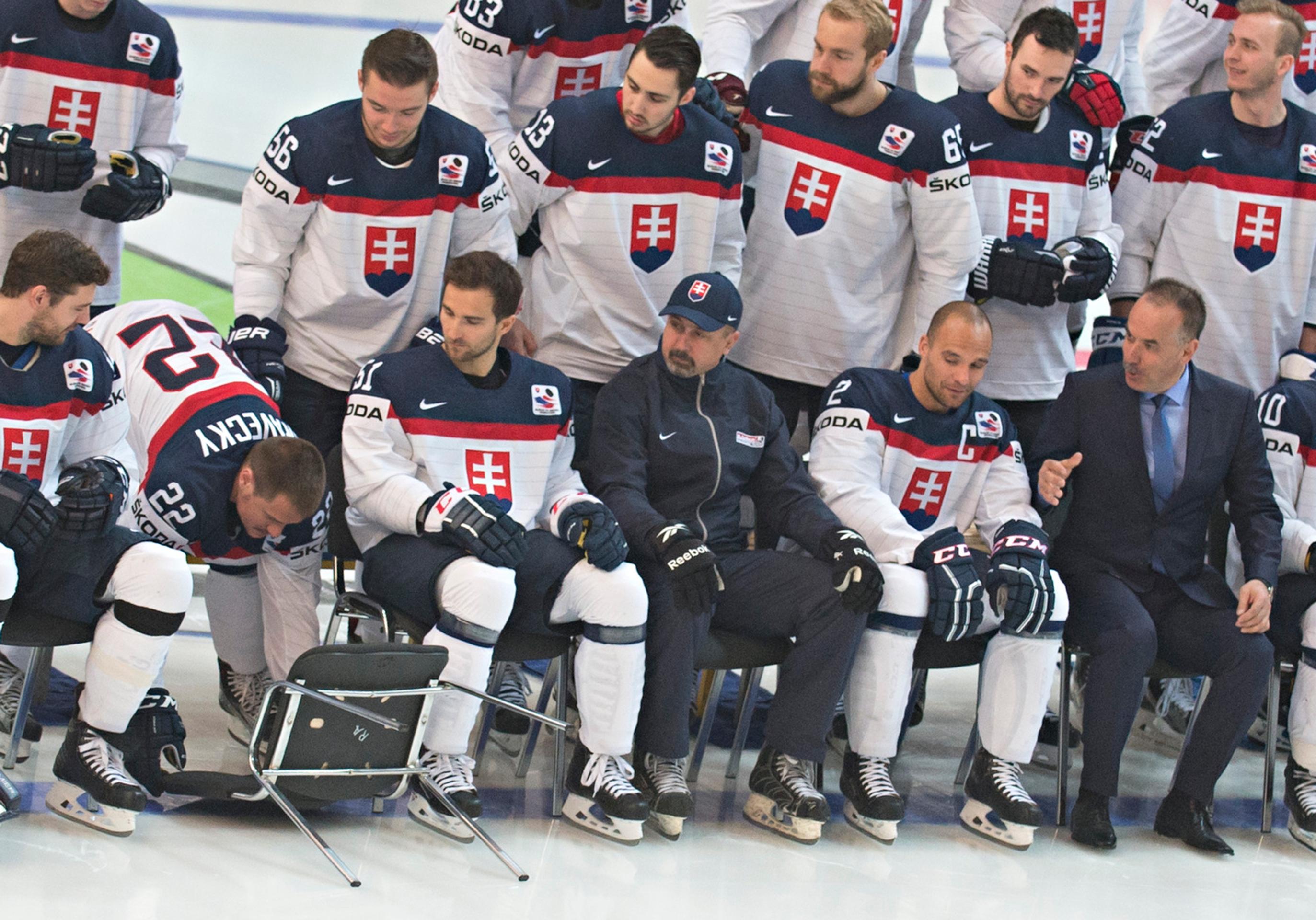 Ostatní pozorujú, kým sa Vladimír pozviecha a zdvihne svoju stoličku.