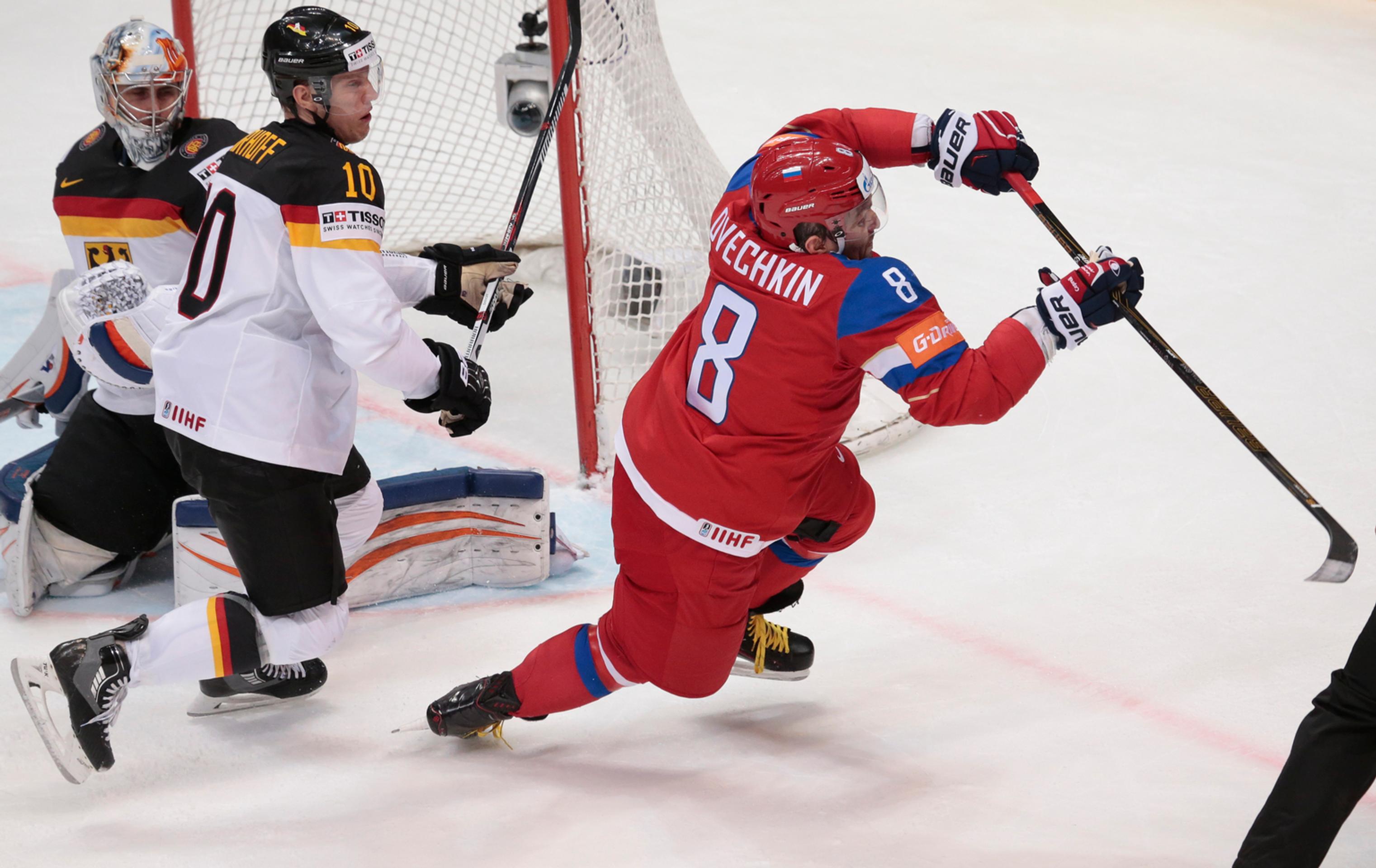 Ruská hviezda Alexander Ovečkin (vpravo) padá v súboji o puk s Nemcom Christianom Ehrhoffom pred nemeckou bránkou v zápase štvrť