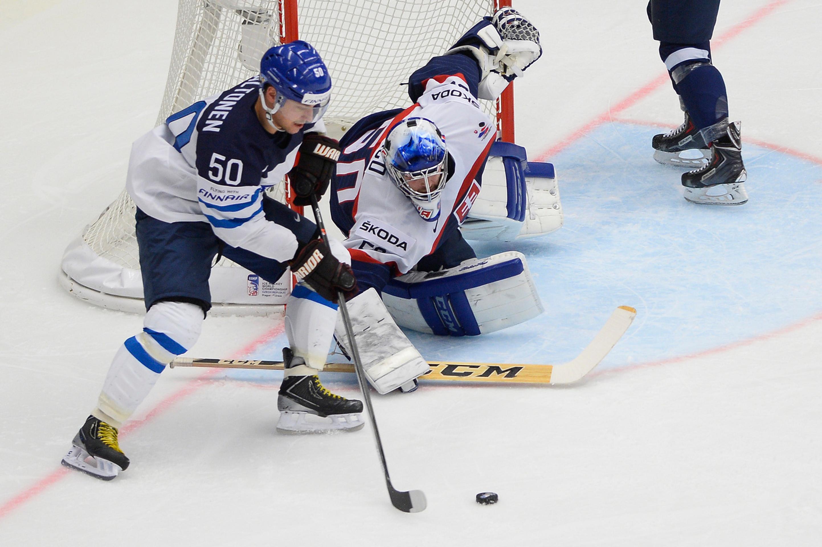 Fínsky hokejista Juhamatti Aaltonen (vľavo) a slovenský brankár Ján Laco